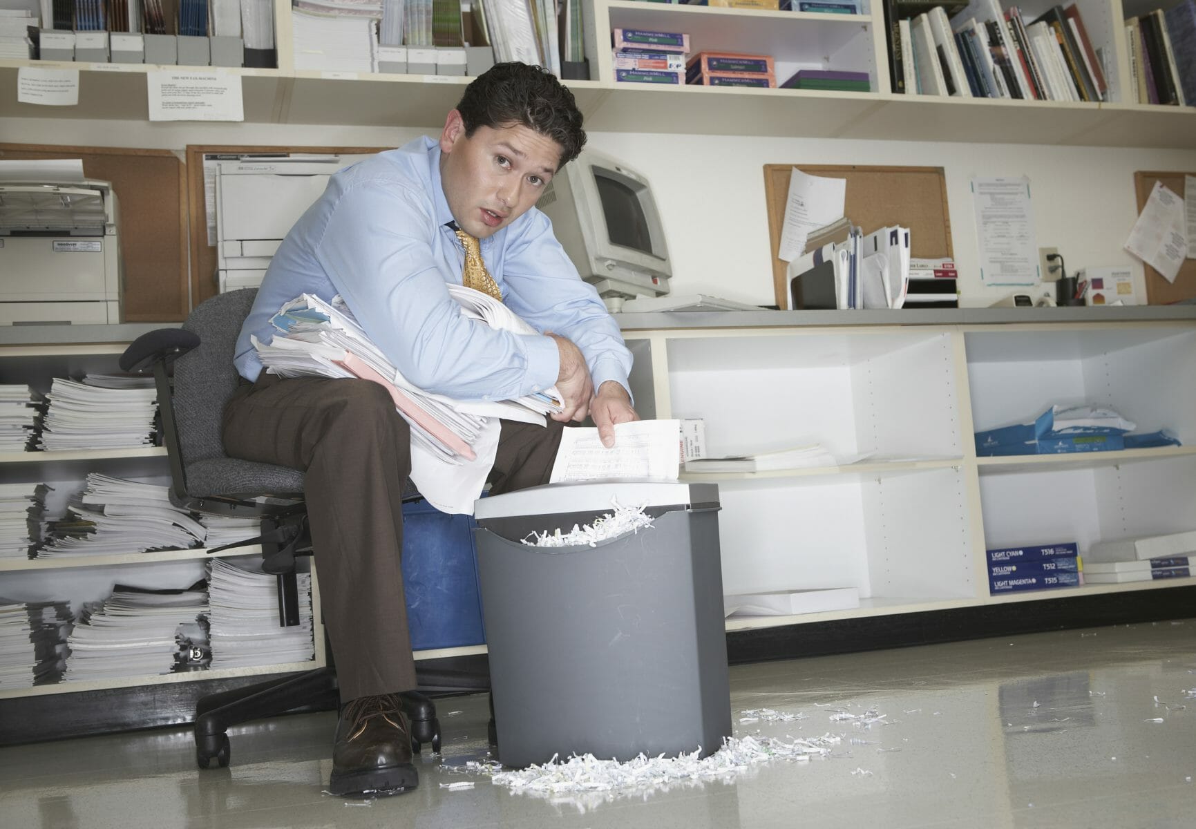Overworked businessman shredding documents Global Document Services, LLC