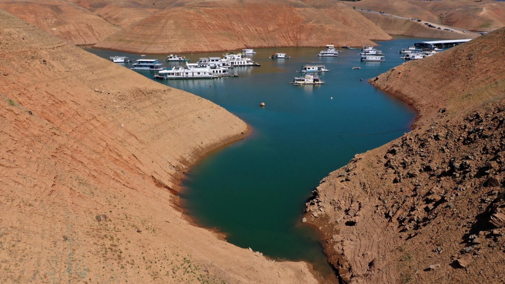 In an aerial view, houseboats float at a water level nearly 200 feet below normal at the Lime Saddle Marina for Lake Oroville near Paradise, California, on Tuesday, June 8, 2021.