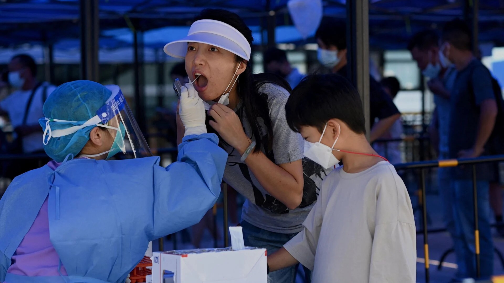 A health worker takes a nucleic acid sample for covid-19 at the arriving passengers terminal at the Zhuhai train station in Zhuhai, in southern China’s Guangdong province on September 27, 2021.