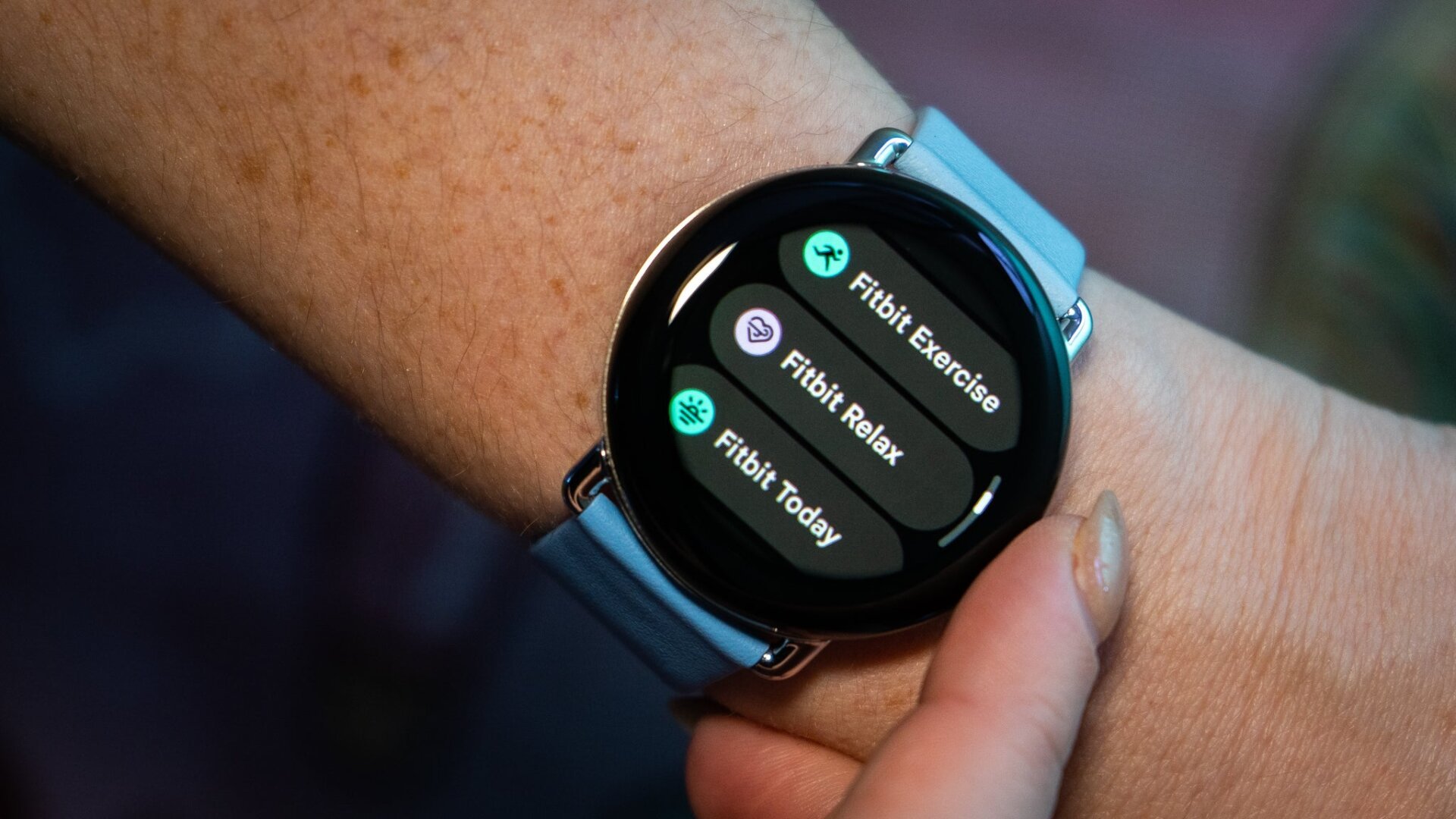 Fitbit features in the Wear OS app drawer on the Pixel Watch 2. The band is the two-tone leather band in Bay.