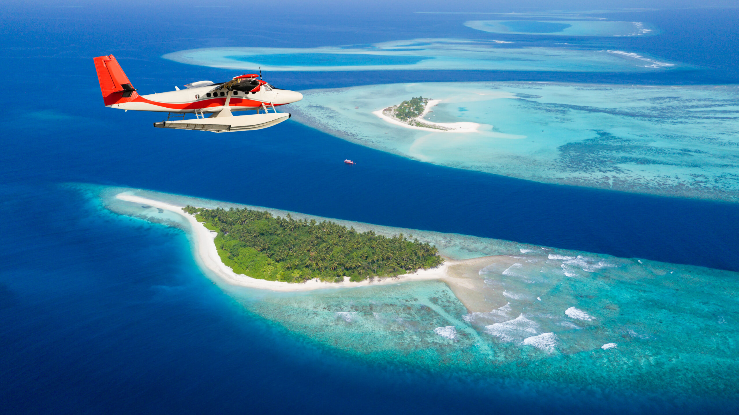 Sea plane flying above Maldives islands Globetrender