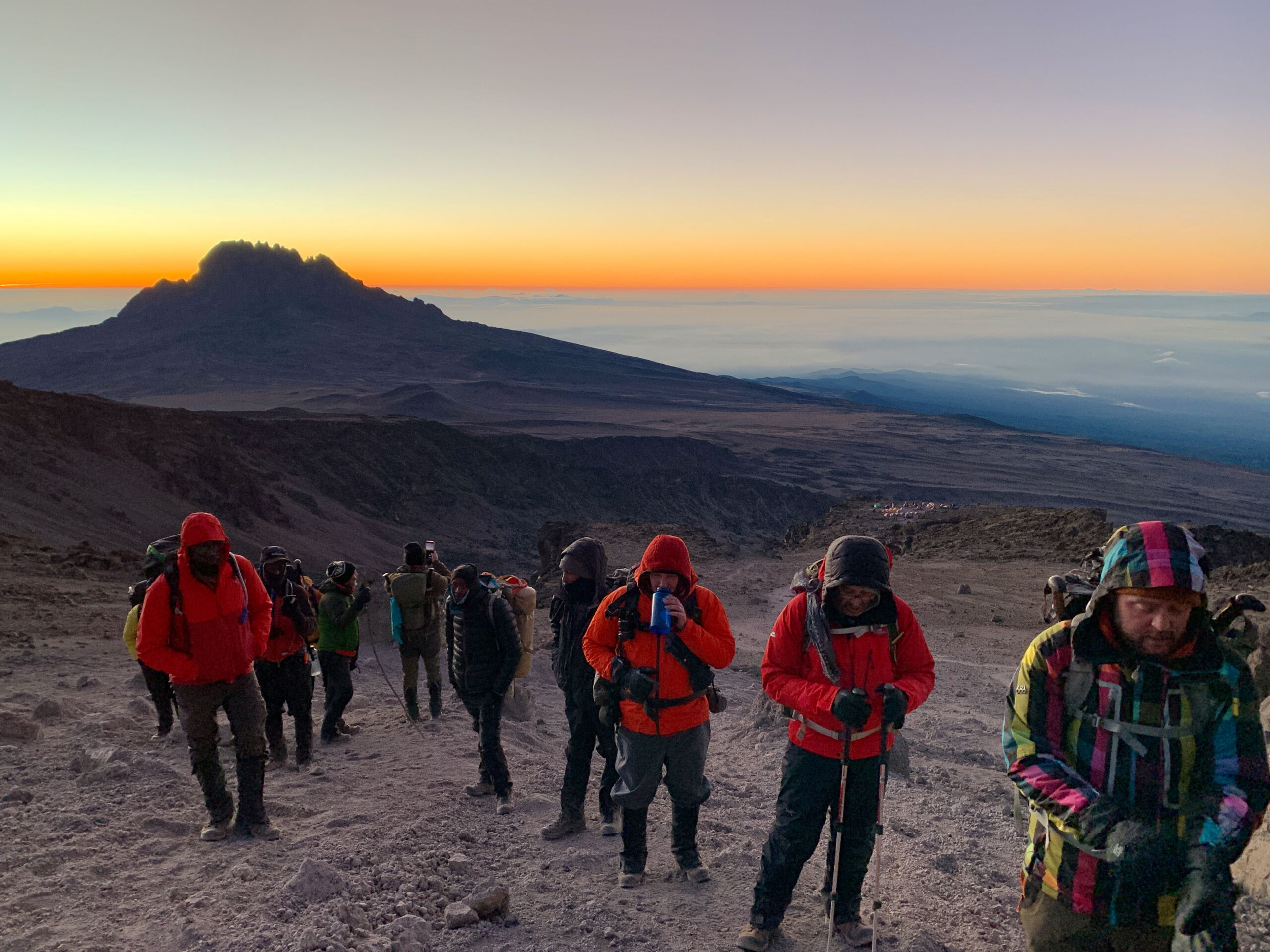 Our group stops for a break on the way to Kilimanjaro's Uhuru Peak with the rising sun chasing behind us.