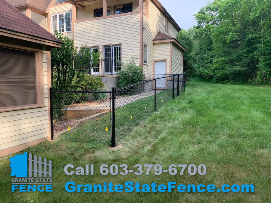 Black vinyl coated chain link fence installed in Windham, NH. Granite