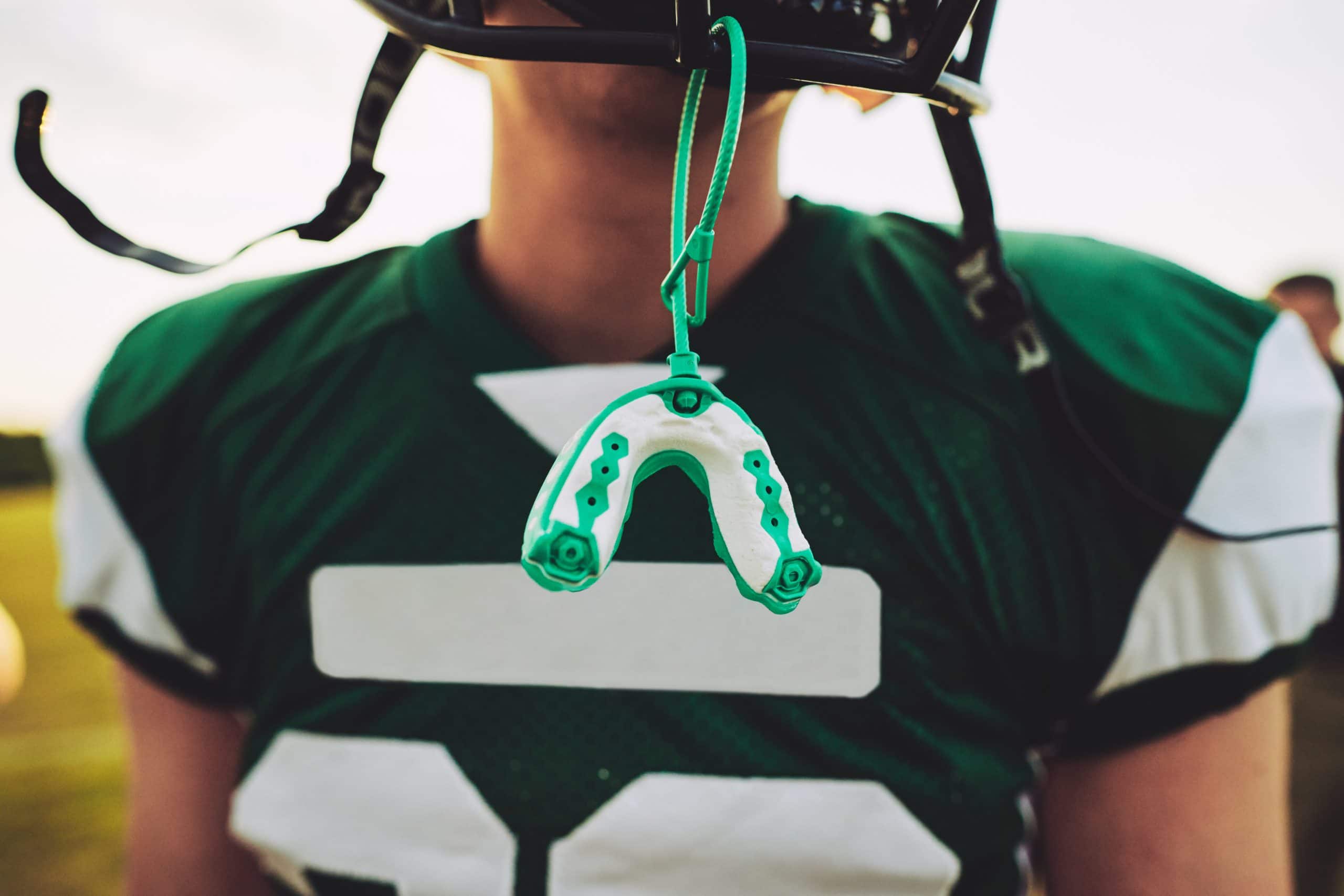 Mouthguard hanging off the helmet of an American football player