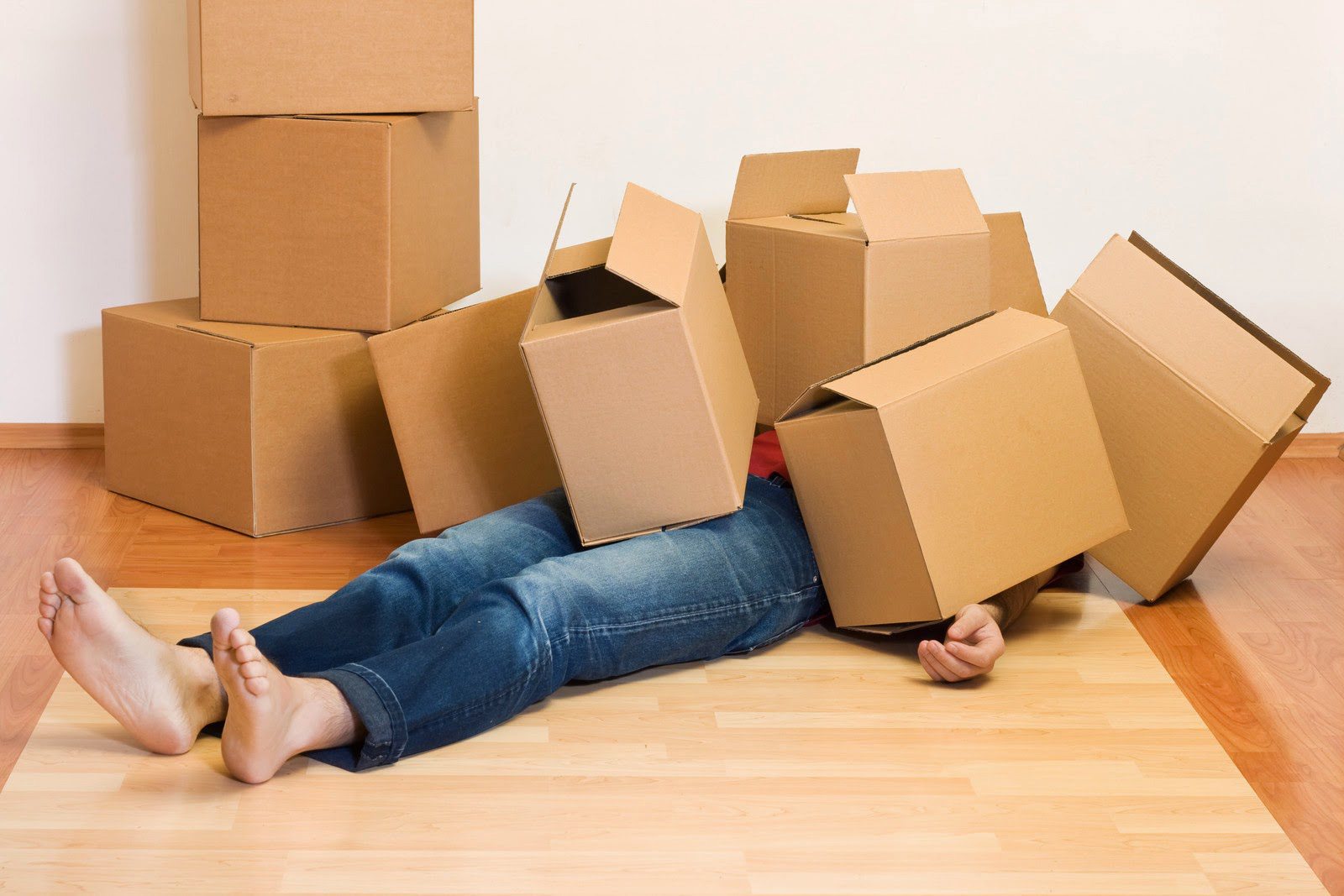 Man lying on floor covered in empty cardboard boxes Hamilton Self Storage
