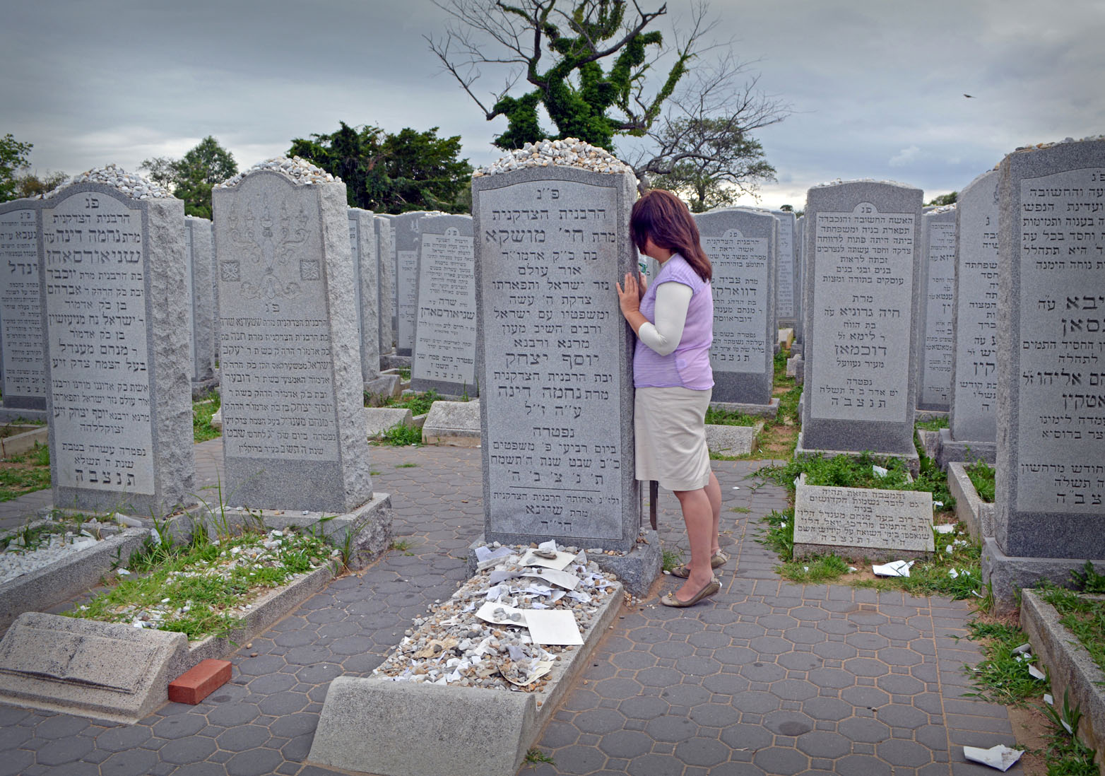 Young religious Jewish woman praying at The Ohel at the burial place of