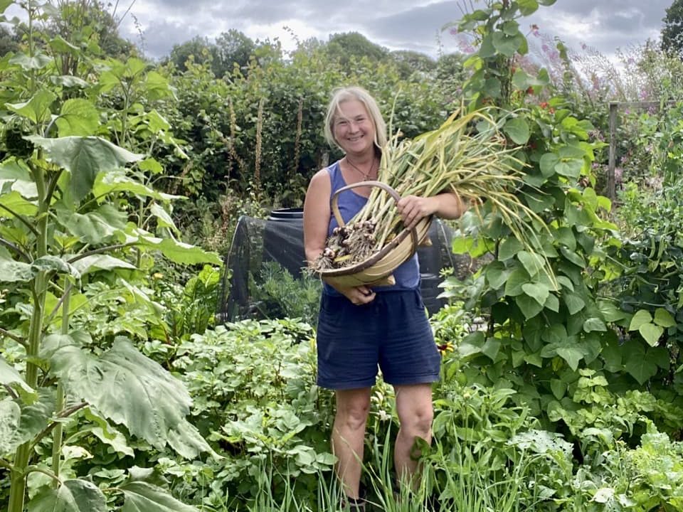 Stephanie with harvested spring onions in her garden