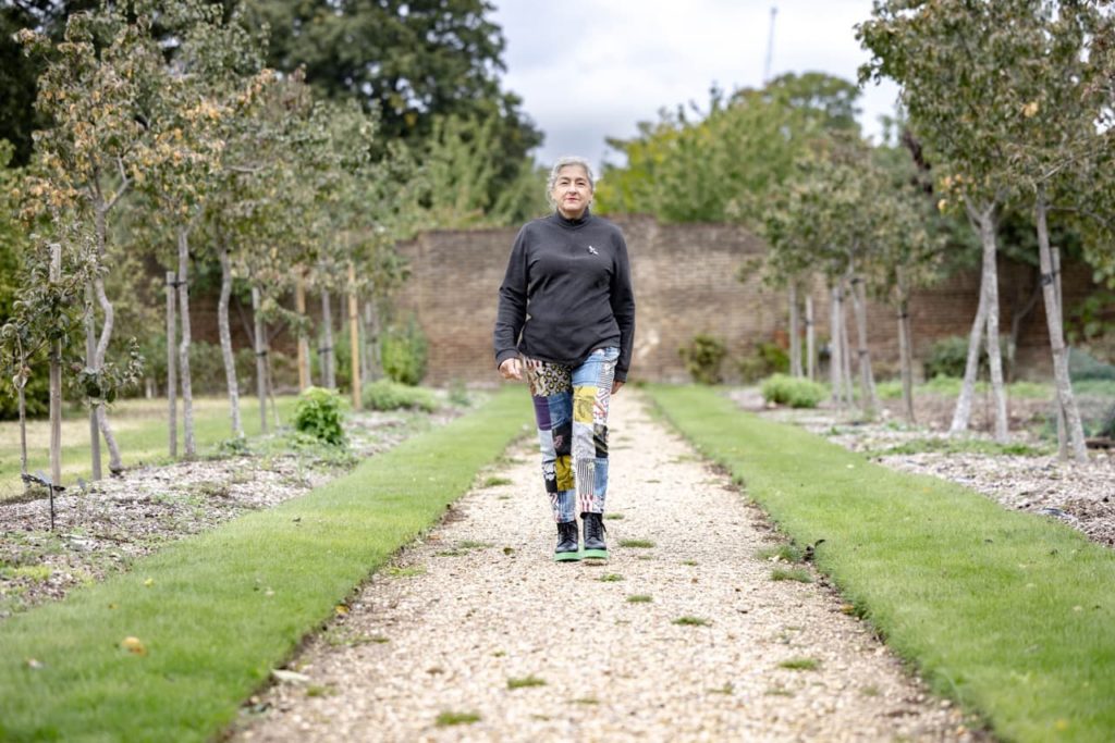 Karen Liebreich walking through an orchid via a gravel path