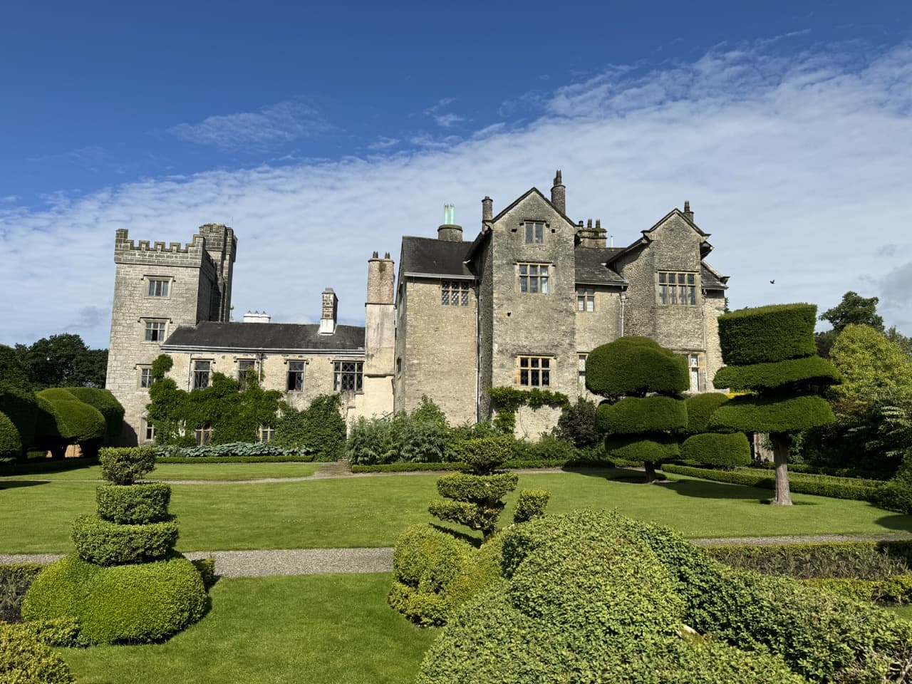 Levens Hall with topiary pieces and a giant grass lawn in front of it