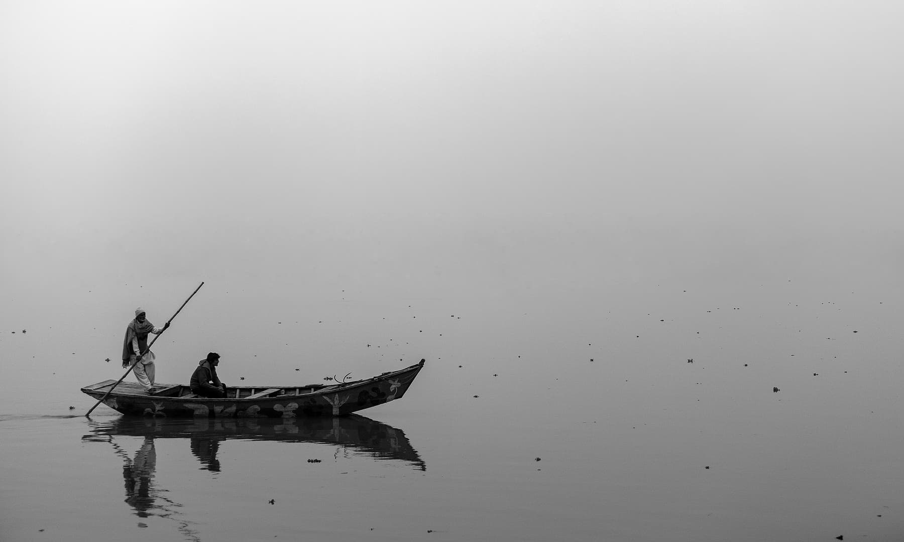 دھند سے لپٹے چناب میں کشتی رانی.— فوٹو سید مہدی بخاری۔