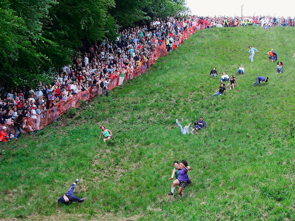 People in the UK Chase Cheese Wheels at the Cooper's Hill Cheese Roll
