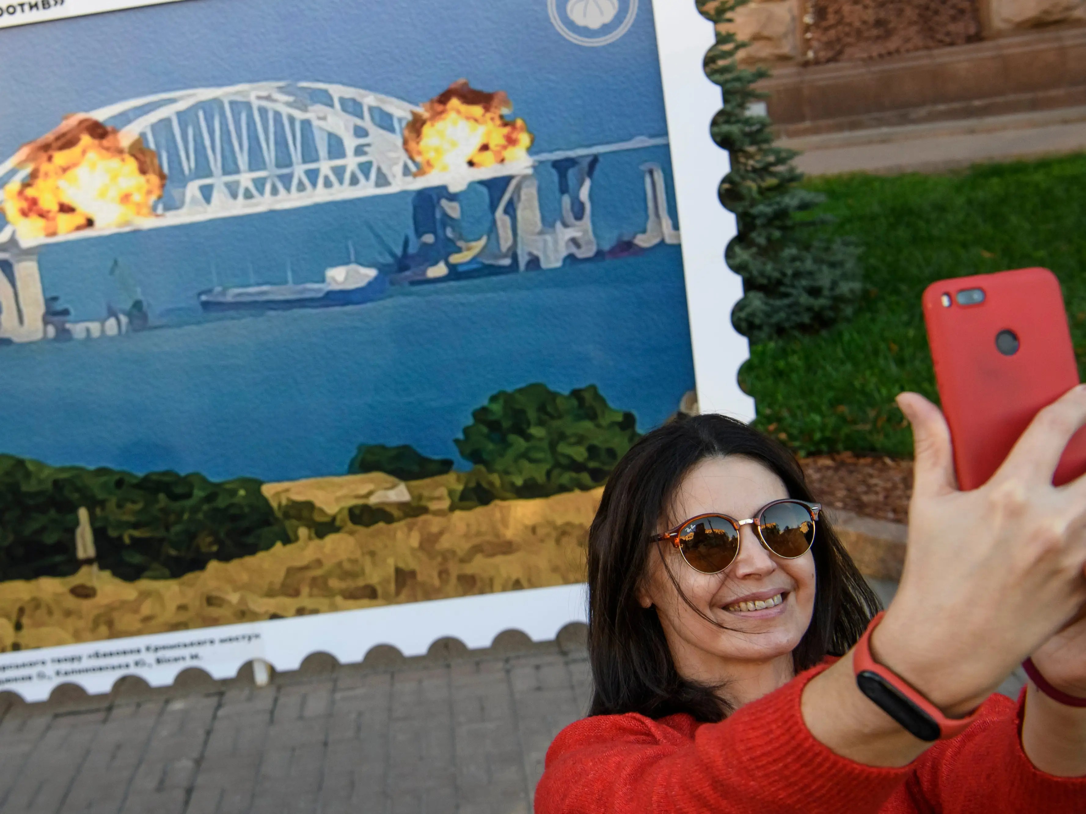 Ukrainians are posing with a giant postage stamp depicting the blown up