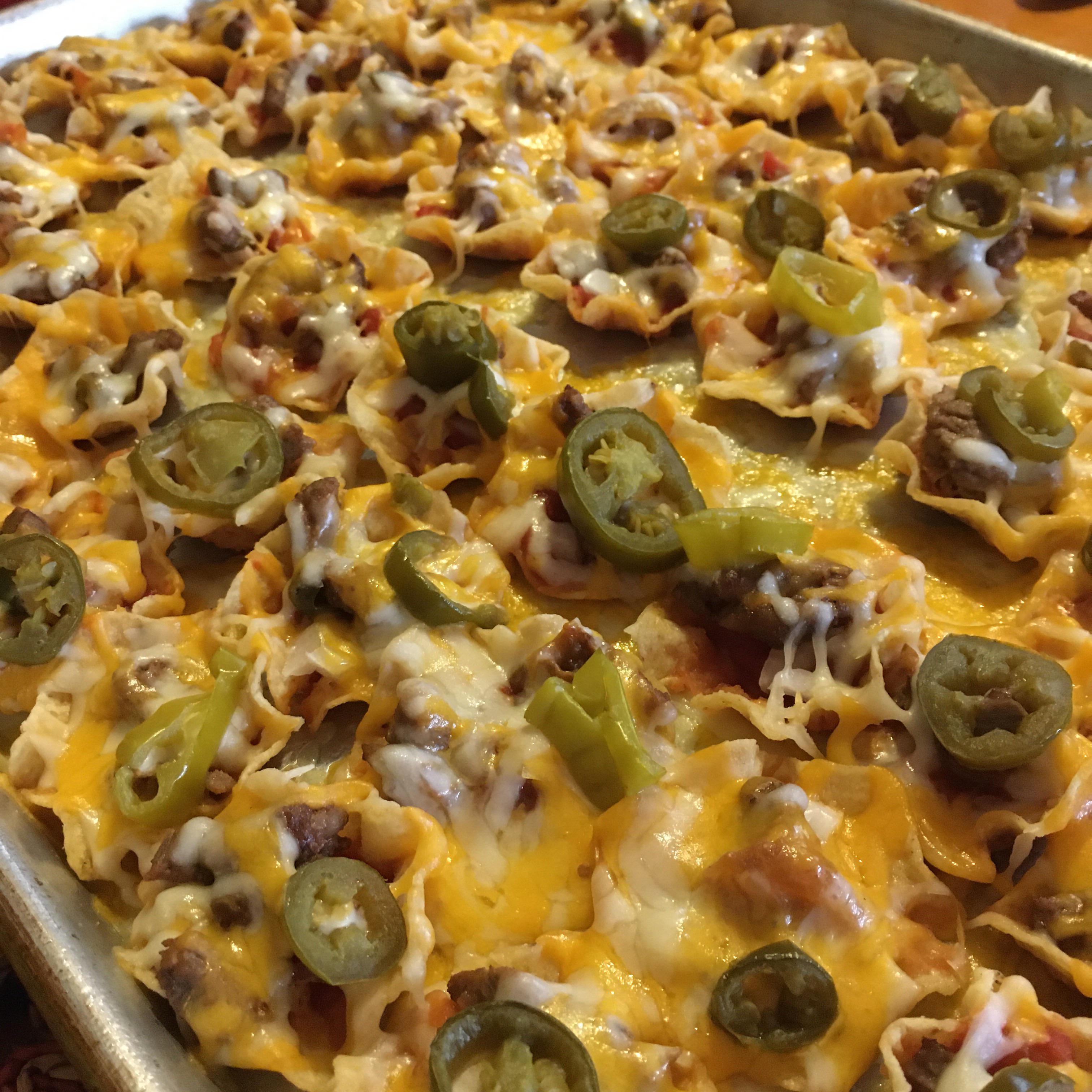 Nachos made out of tortilla chips, salsa, diced onion, leftover steak