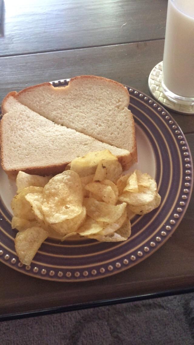 Peanut butter sandwich with potato chips and a glass of milk. Childish