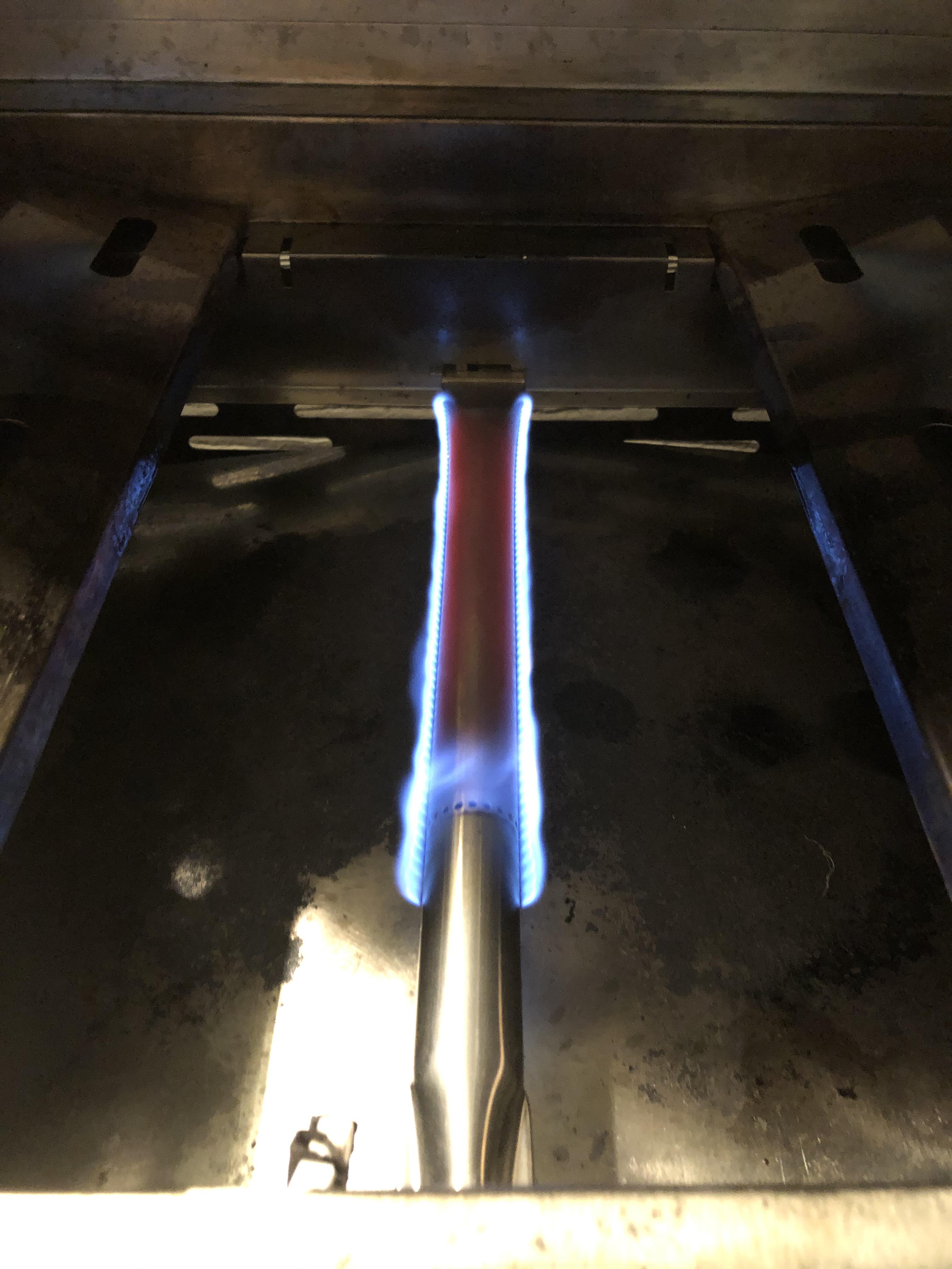 Natural gas grill burner tube glows red when on lowest flame, what