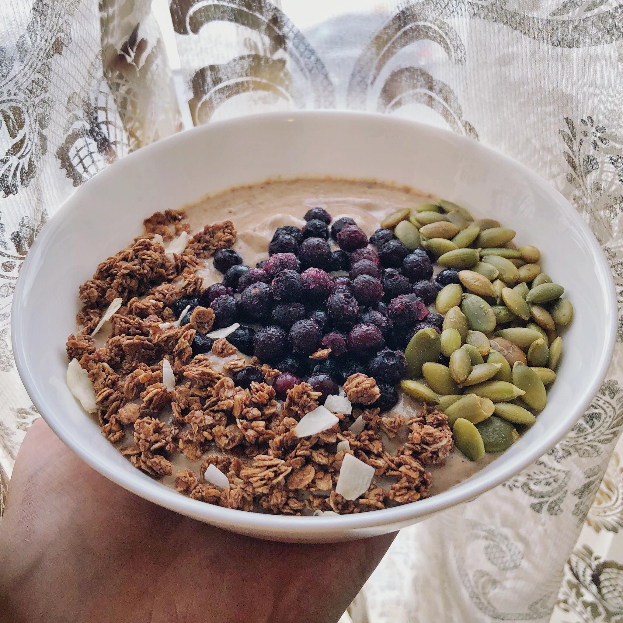 Protein yogurt bowl topped with coconut granola, frozen berries and
