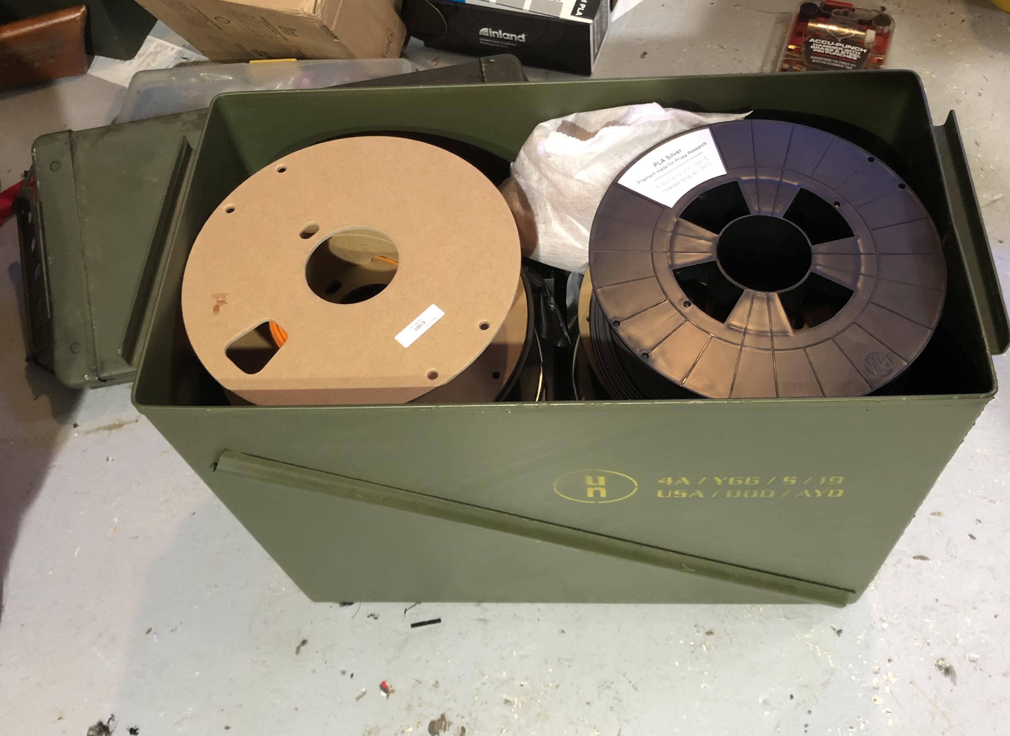 A 30mm ammo can will hold up to 10 1kg spools of filament and is air