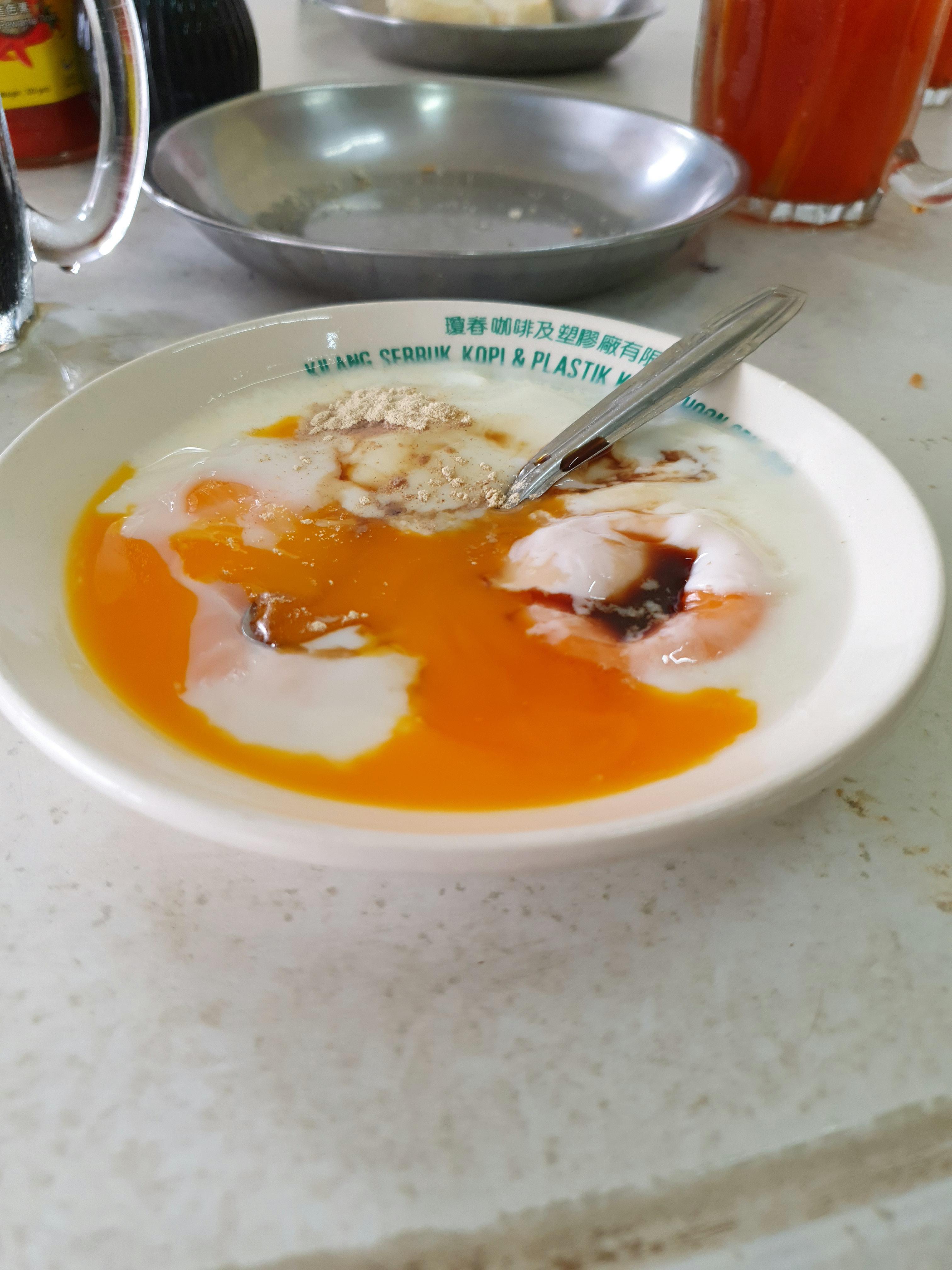 Breakfast half boiled eggs with a dash of soy sauce and white pepper