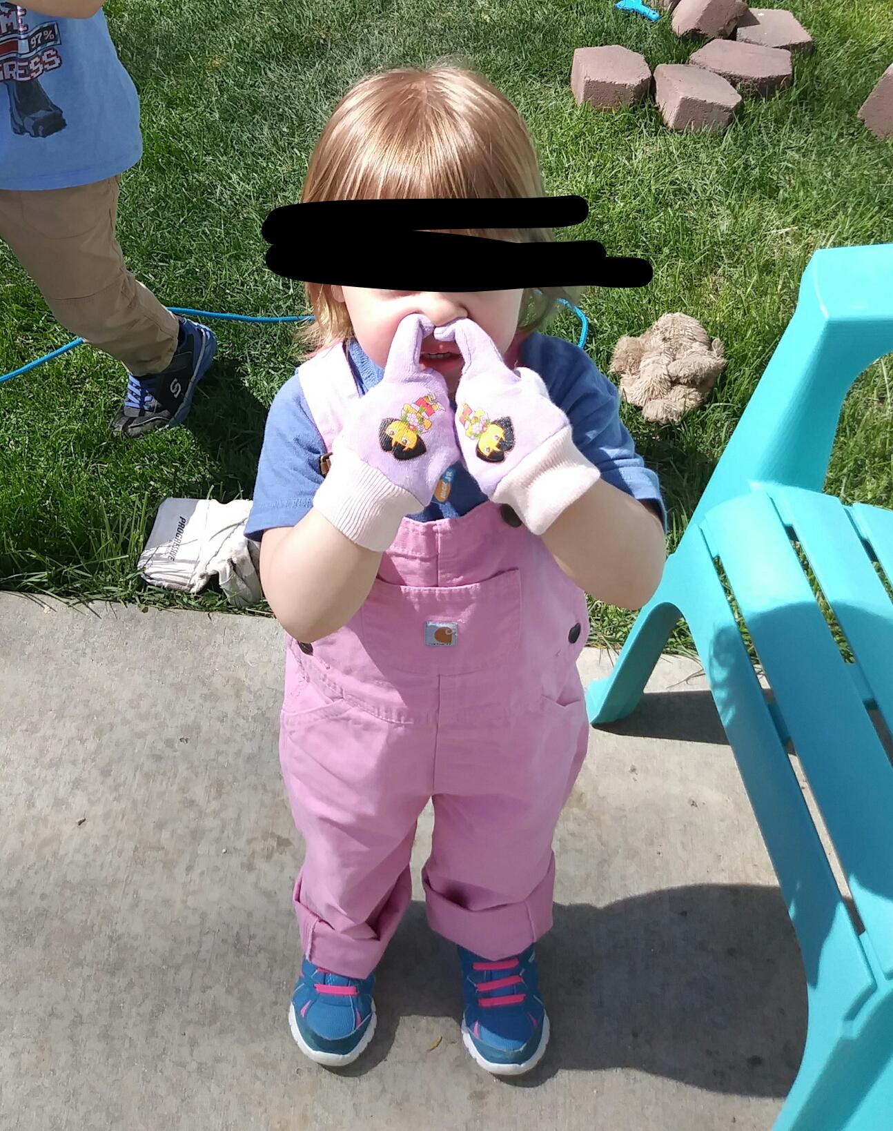 The 2 year old doesn't like her gardening gloves because they prevent