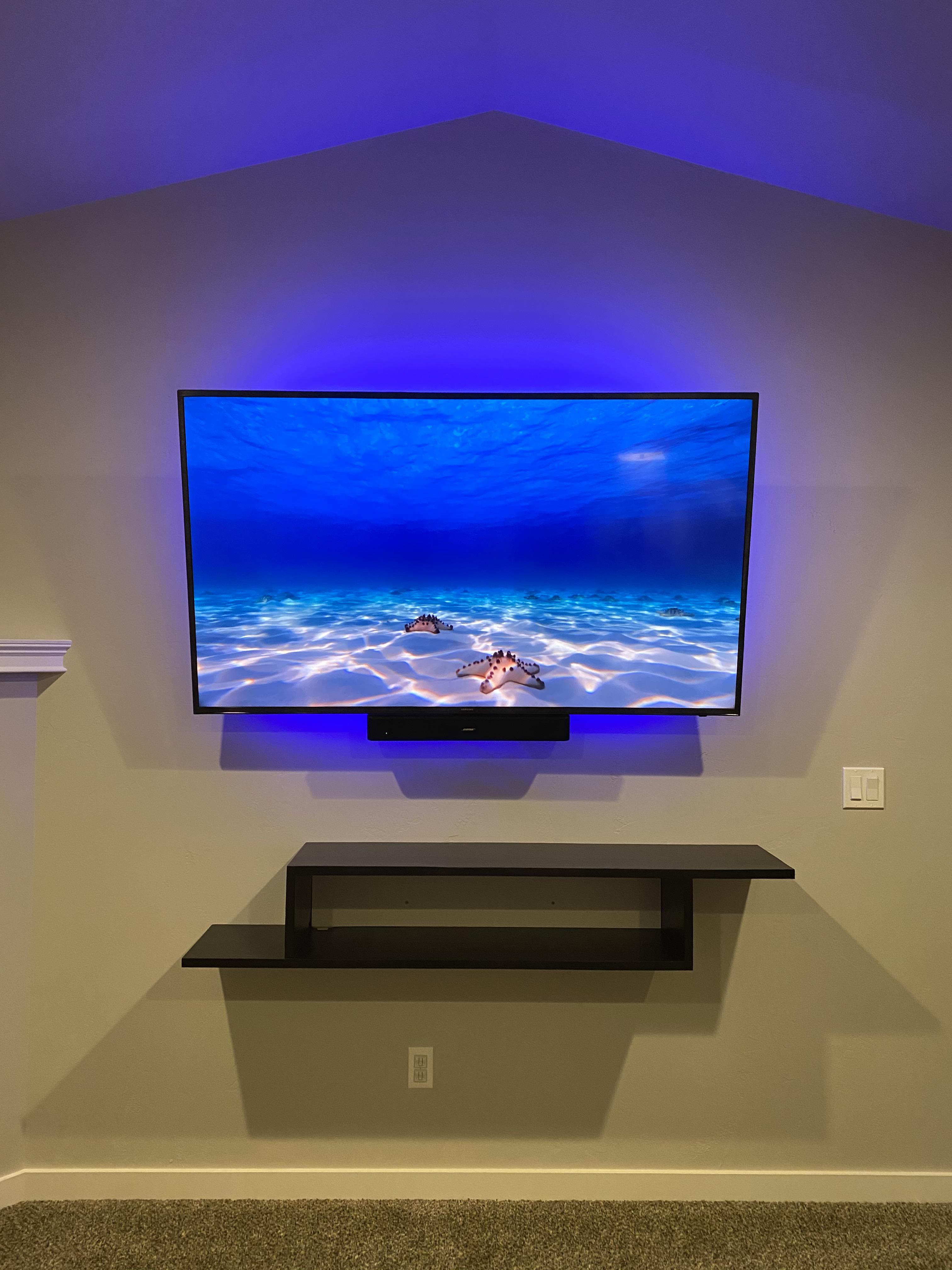 Newly mounted tv and shelf. Colors of lights behind will change