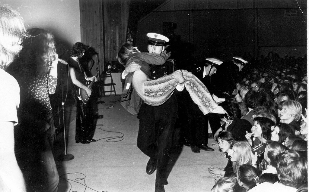 Icelandic police officers carries a woman off a Led Zeppelin concert