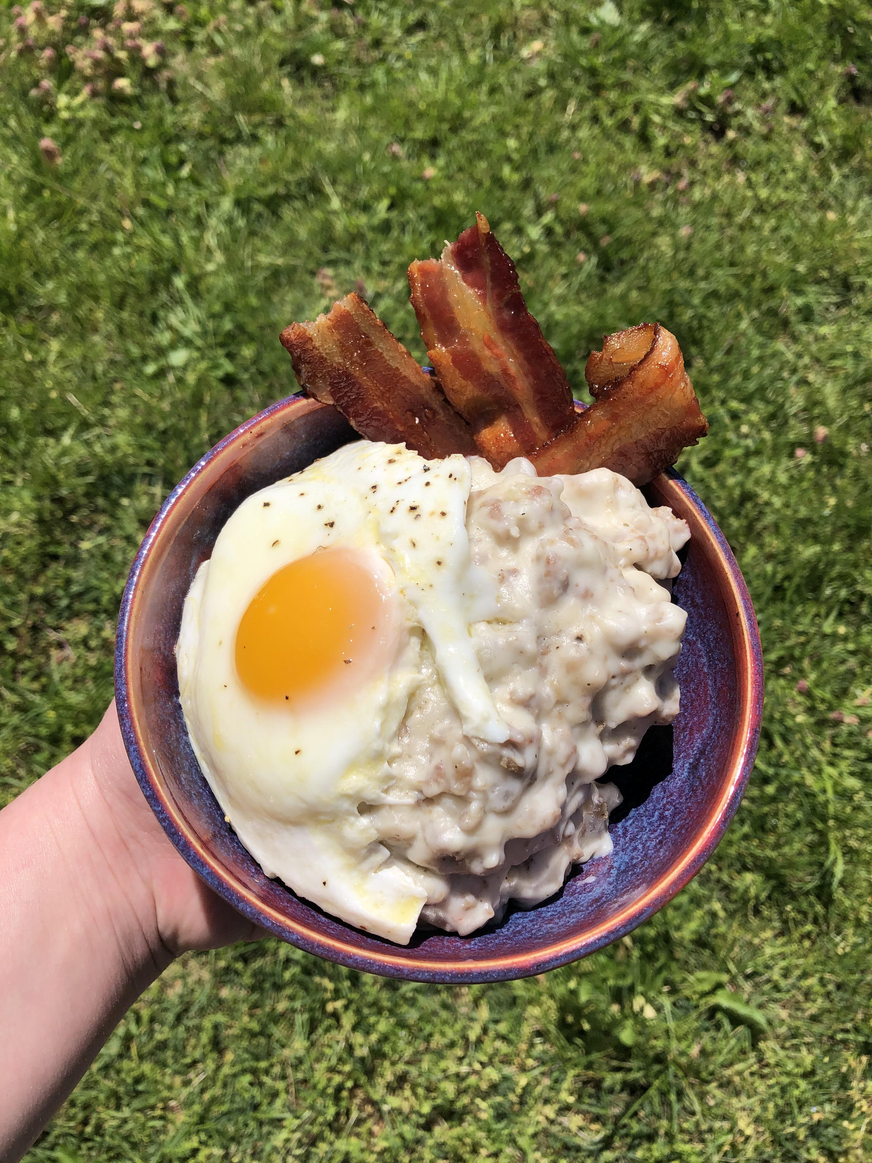 Biscuits and gravy with my first fried egg and some bacon r/FoodPorn