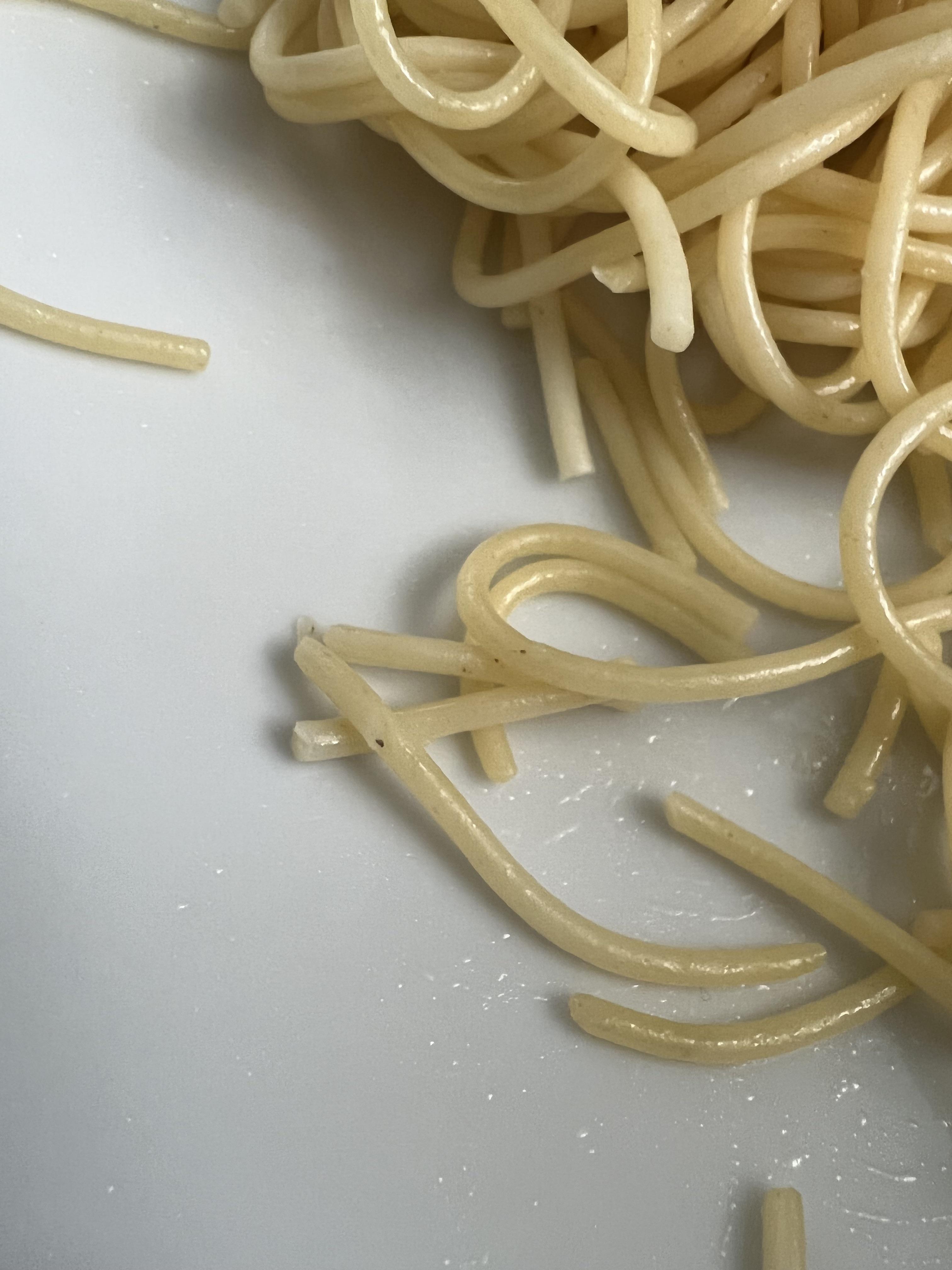 What causes these dots found on cooked pasta? Is it unprocessed grain