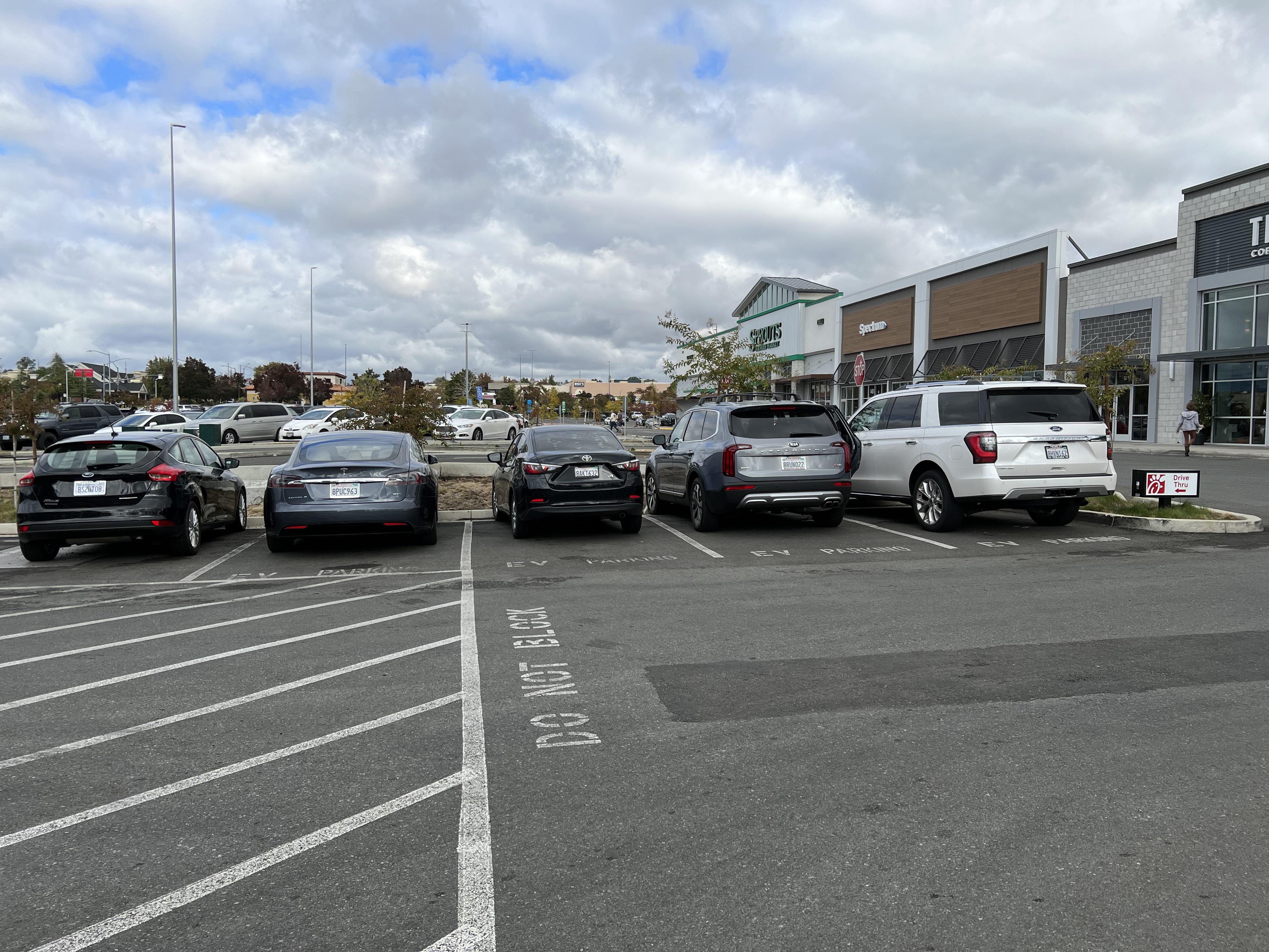 Three electric vehicle parking spots taken up by nonelectric vehicles