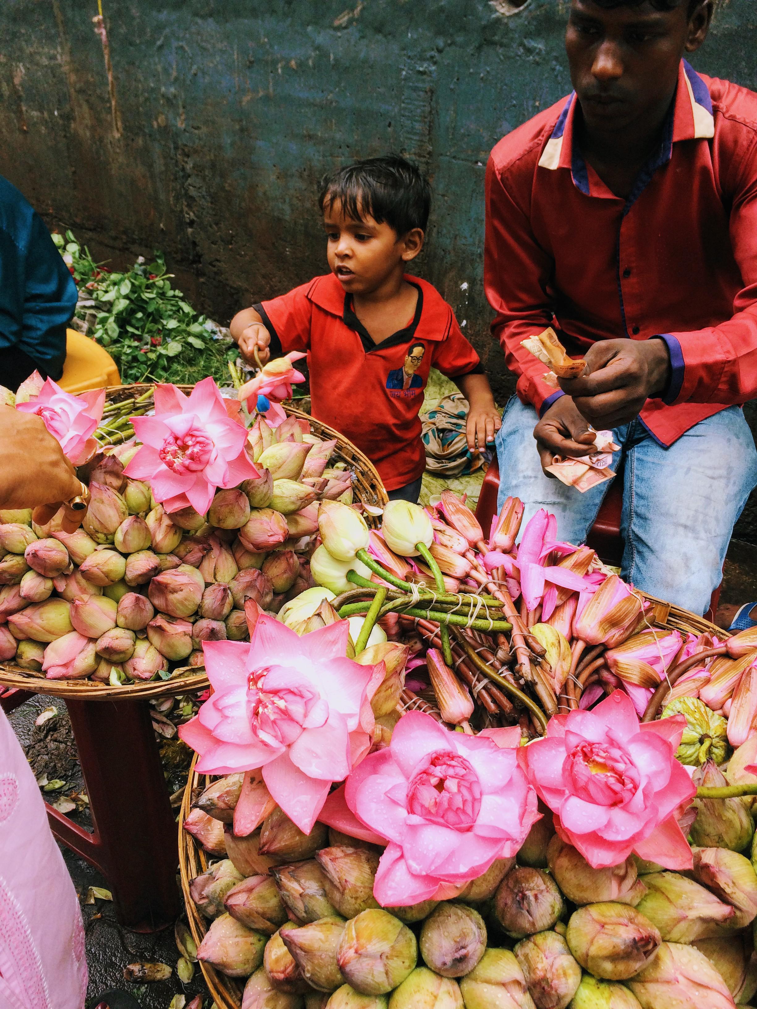 A small boy selling flowers at Dadar phool galli on a busy Sunday