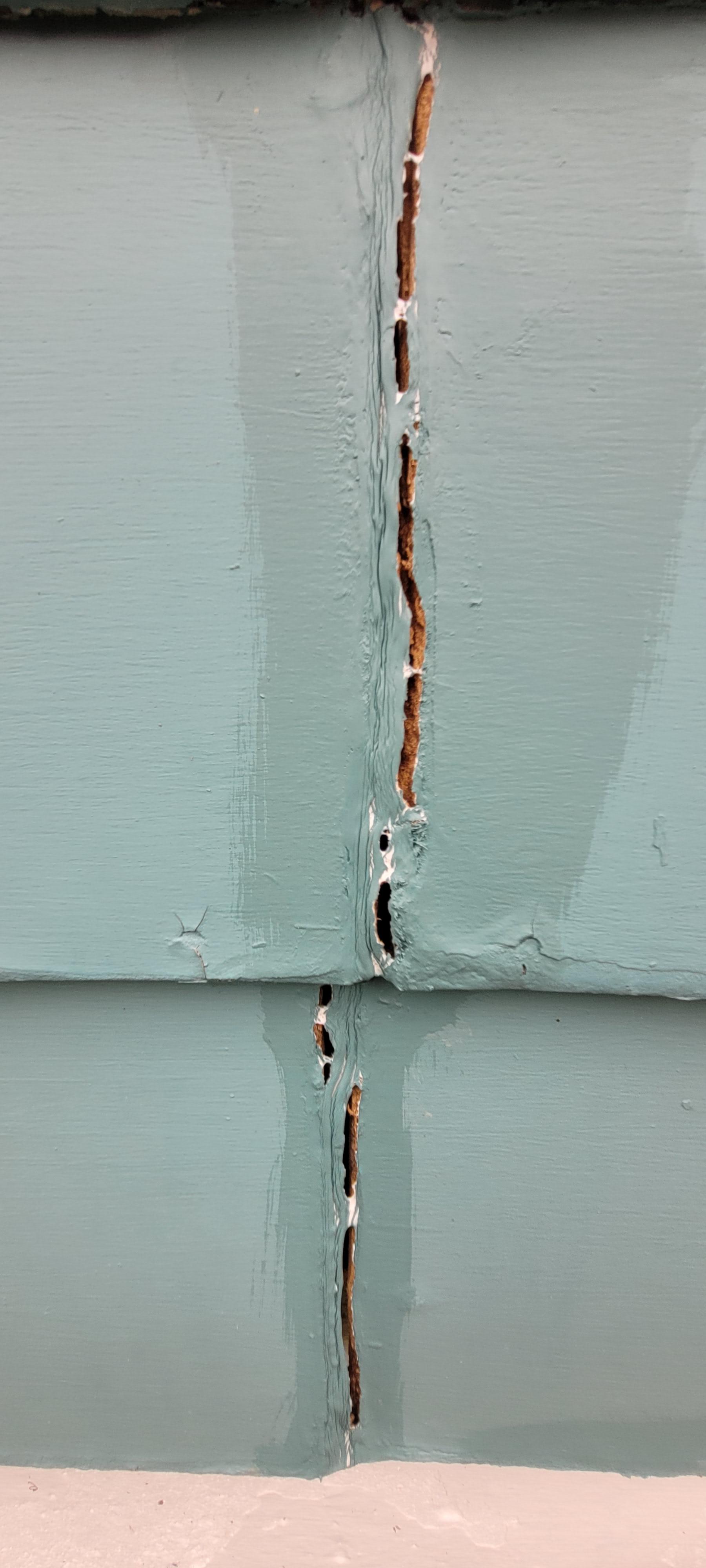 What should I fill these cracks on my Masonite siding with before