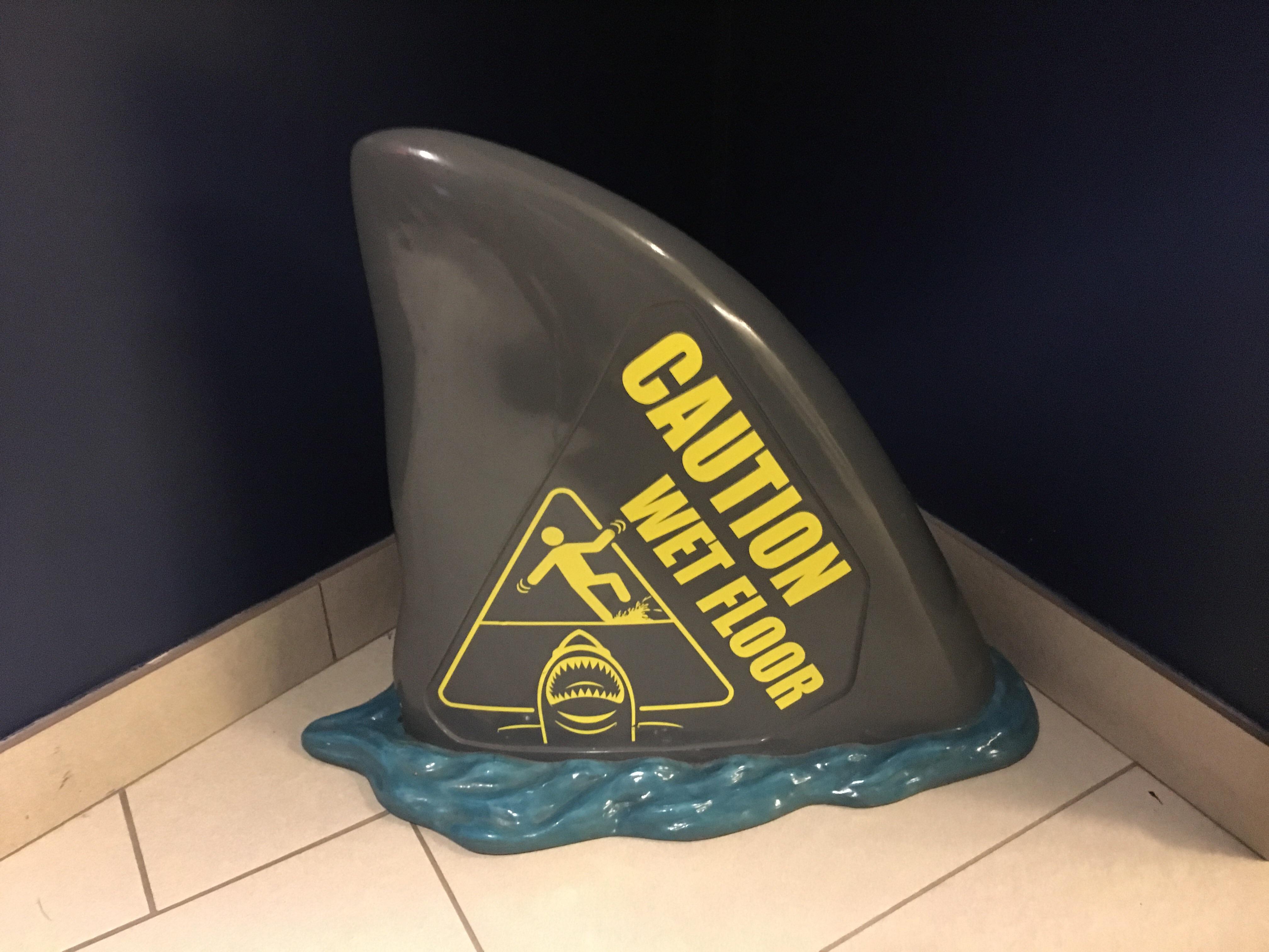 Toronto Aquarium's "caution wet floor" signs are shaped like shark fins