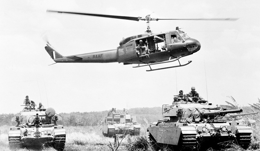 Australian Air Force Huey hovers over a Centurion tanks during the
