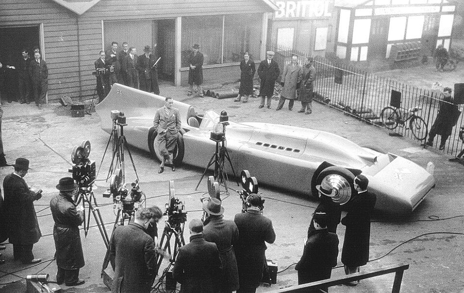 English racing motorist Sir Malcolm Campbell poses for the cameras with