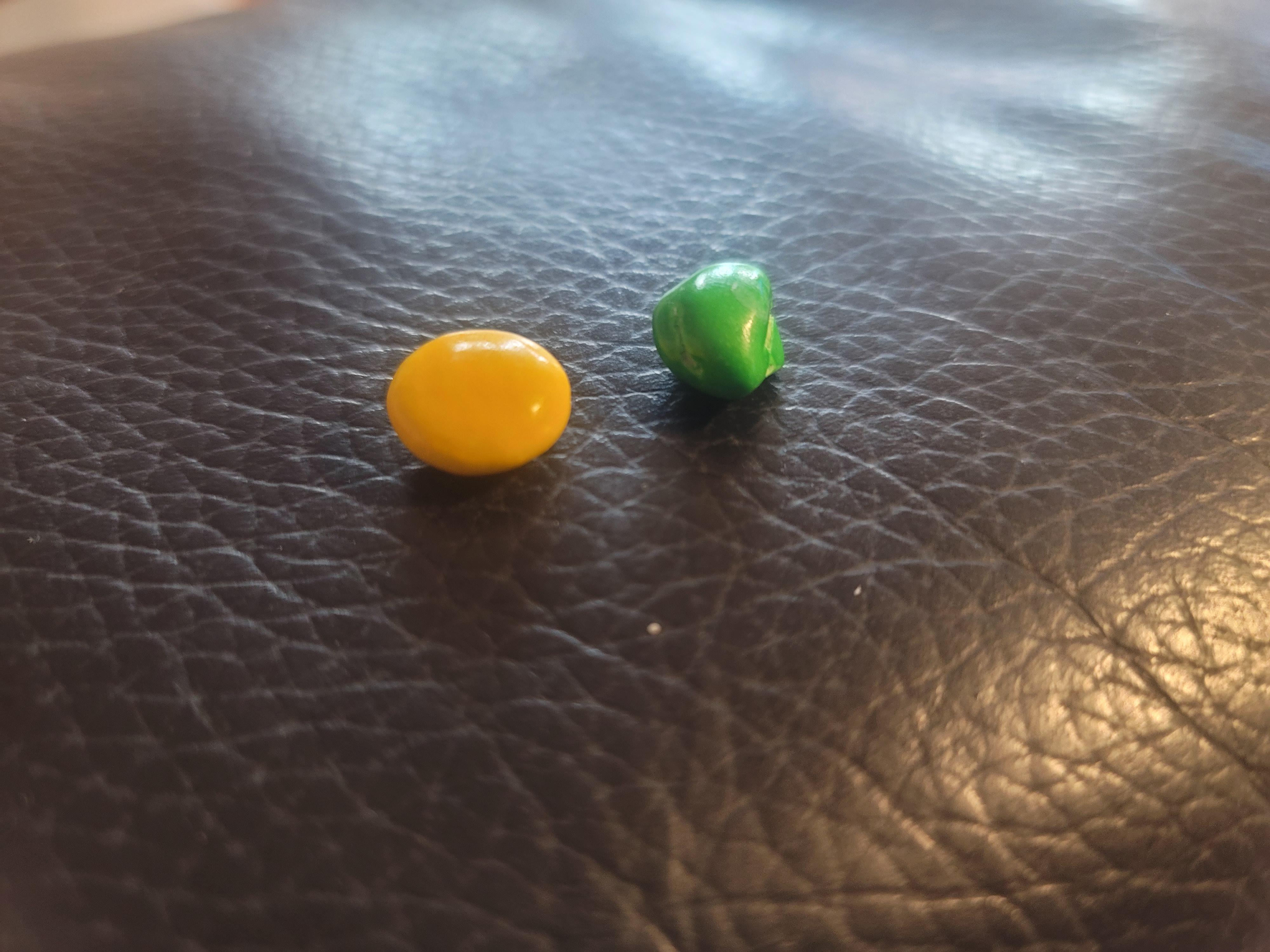 Weirdly shaped m&m [normal m&m for reference] r/mildlyinteresting