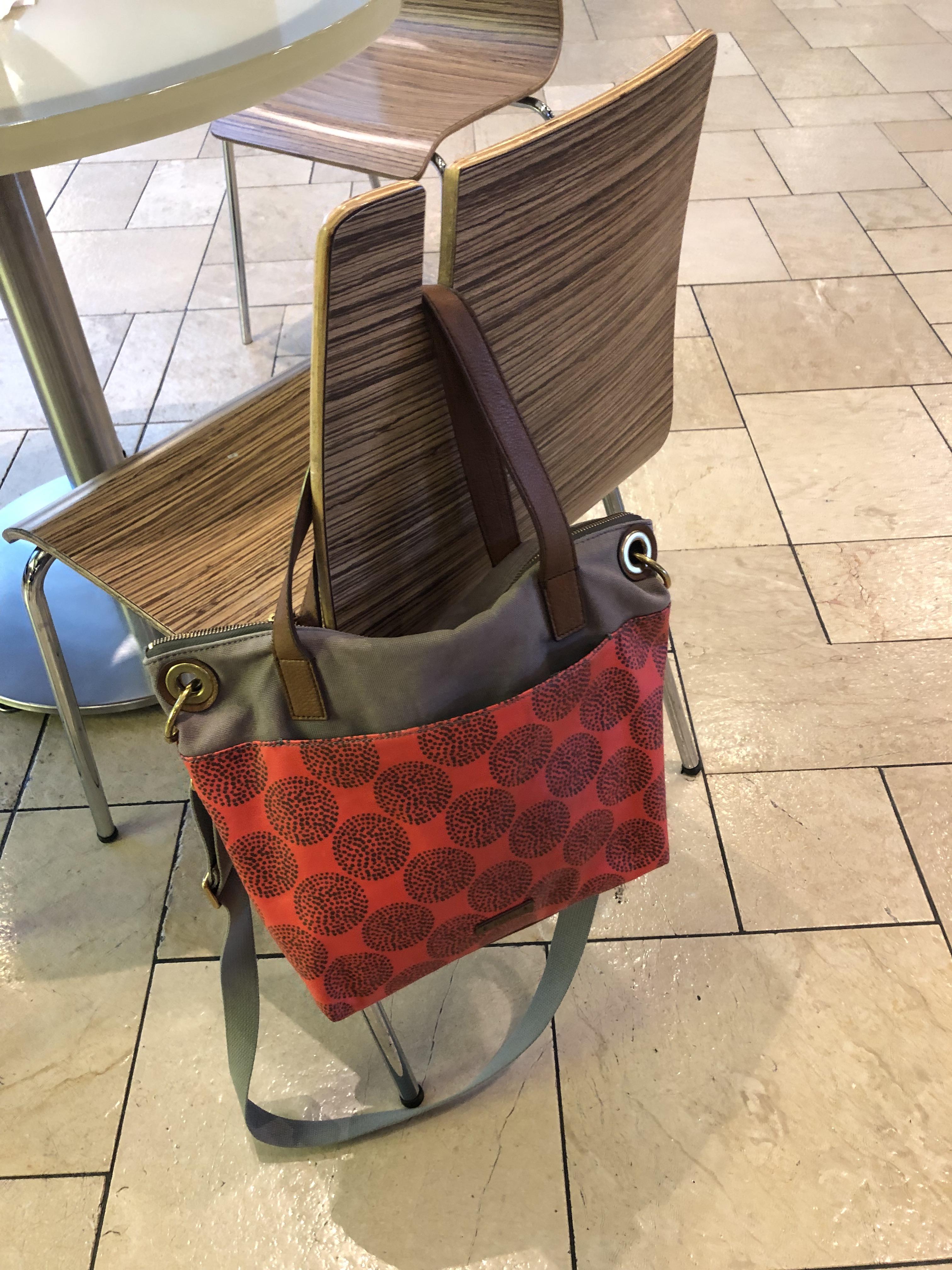 The chairs in the food court of this mall have a slot to hang your