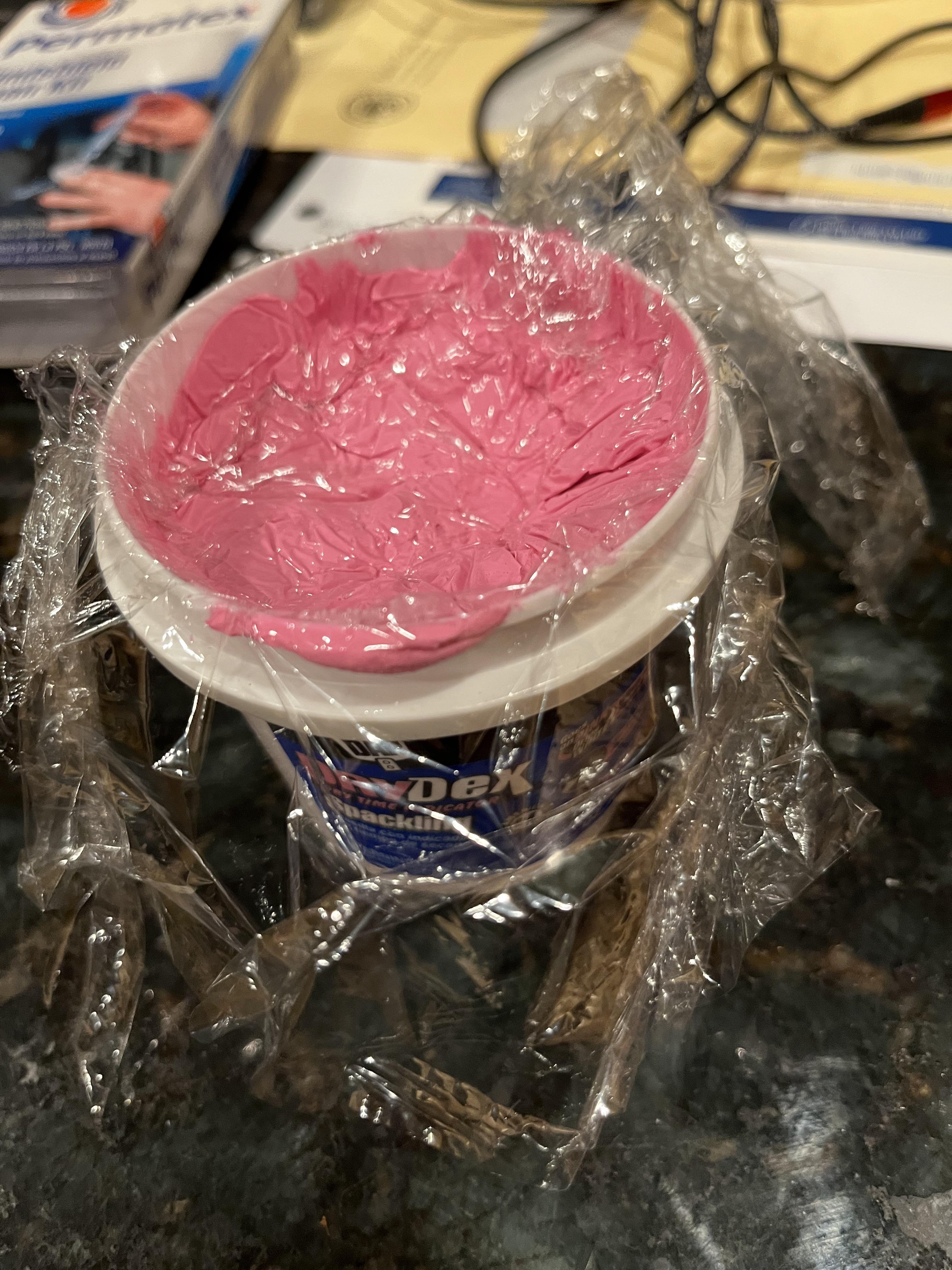 Put saran wrap over your spackle before you put the lid on and store it