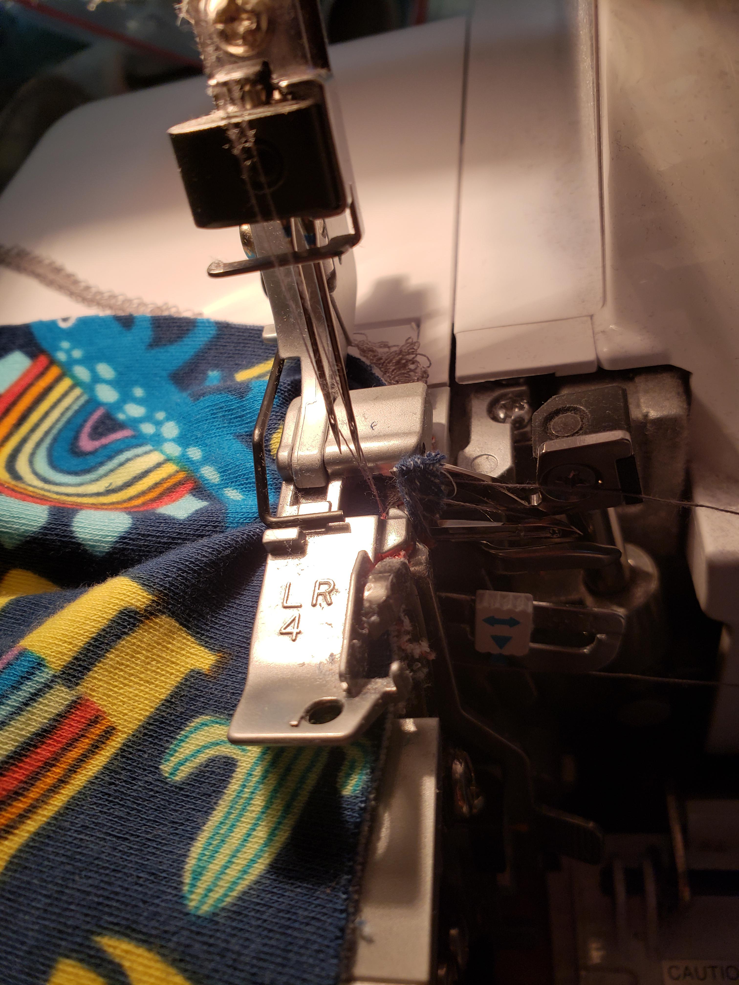 My serger keeps catching fabric on the looper arms. The feed dogs eat