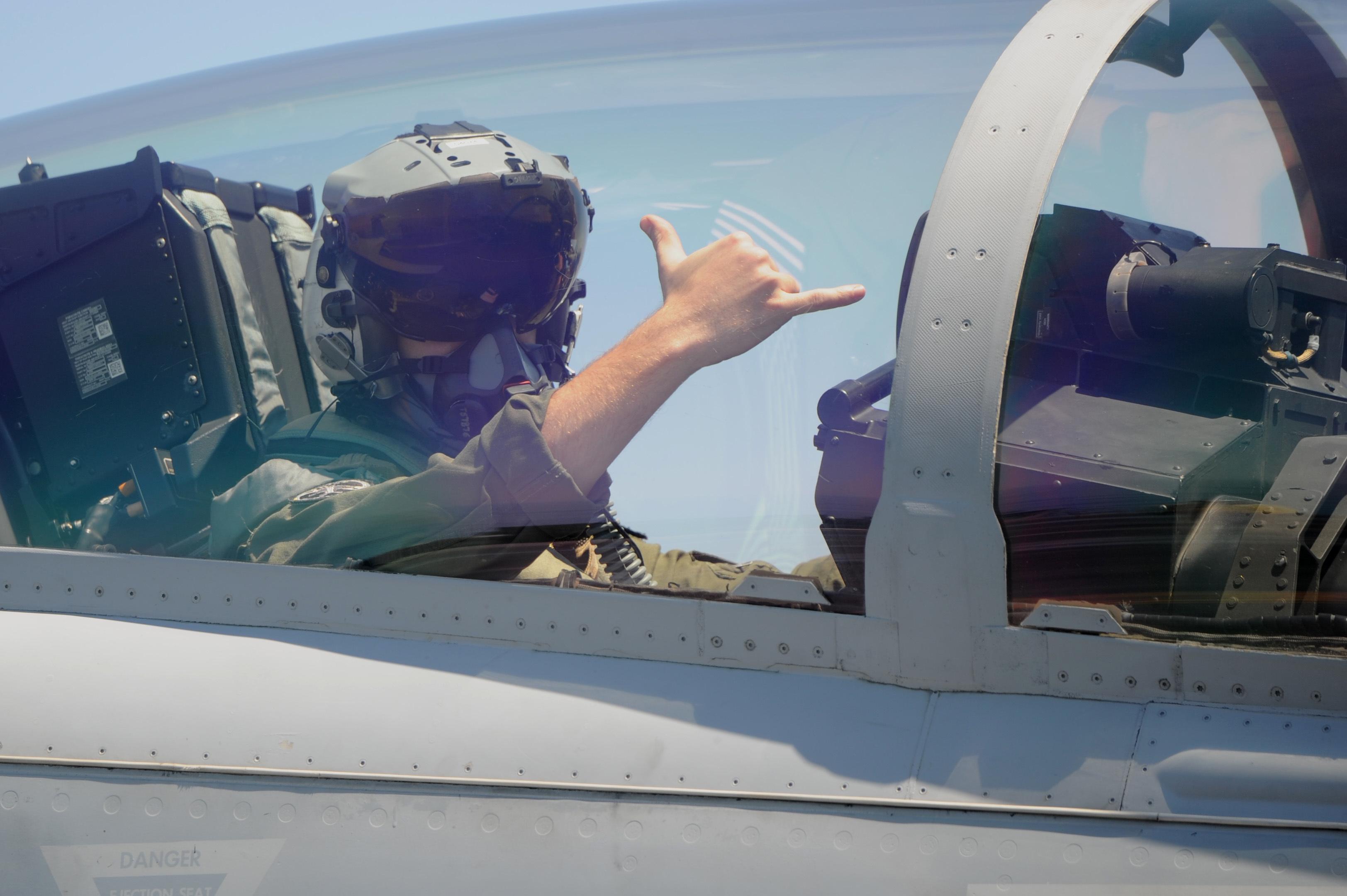 A Navy pilot gives the ok signal as he prepares to launch from the