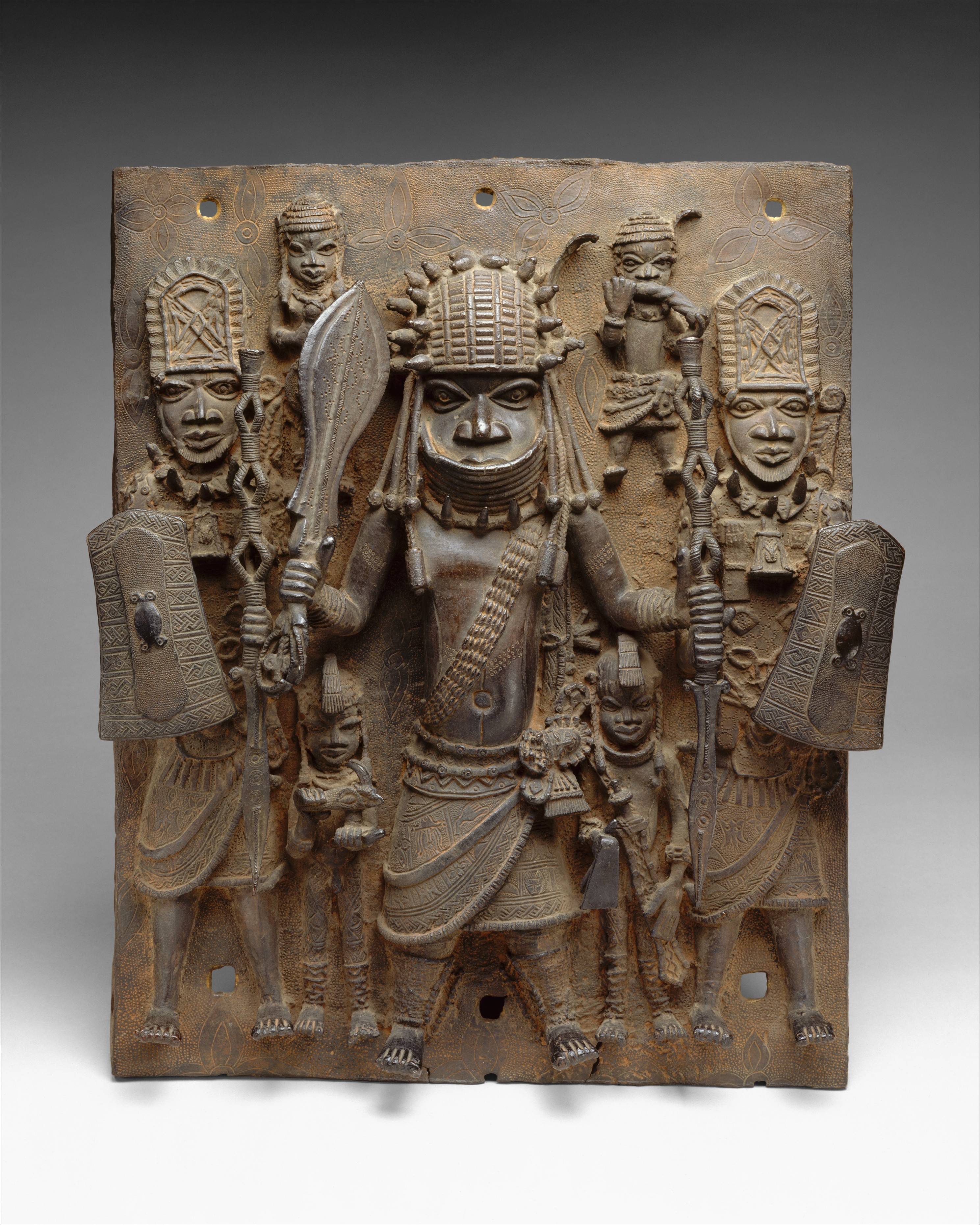 A Benin brass plaque depicting a chief warrior and attendants. From the