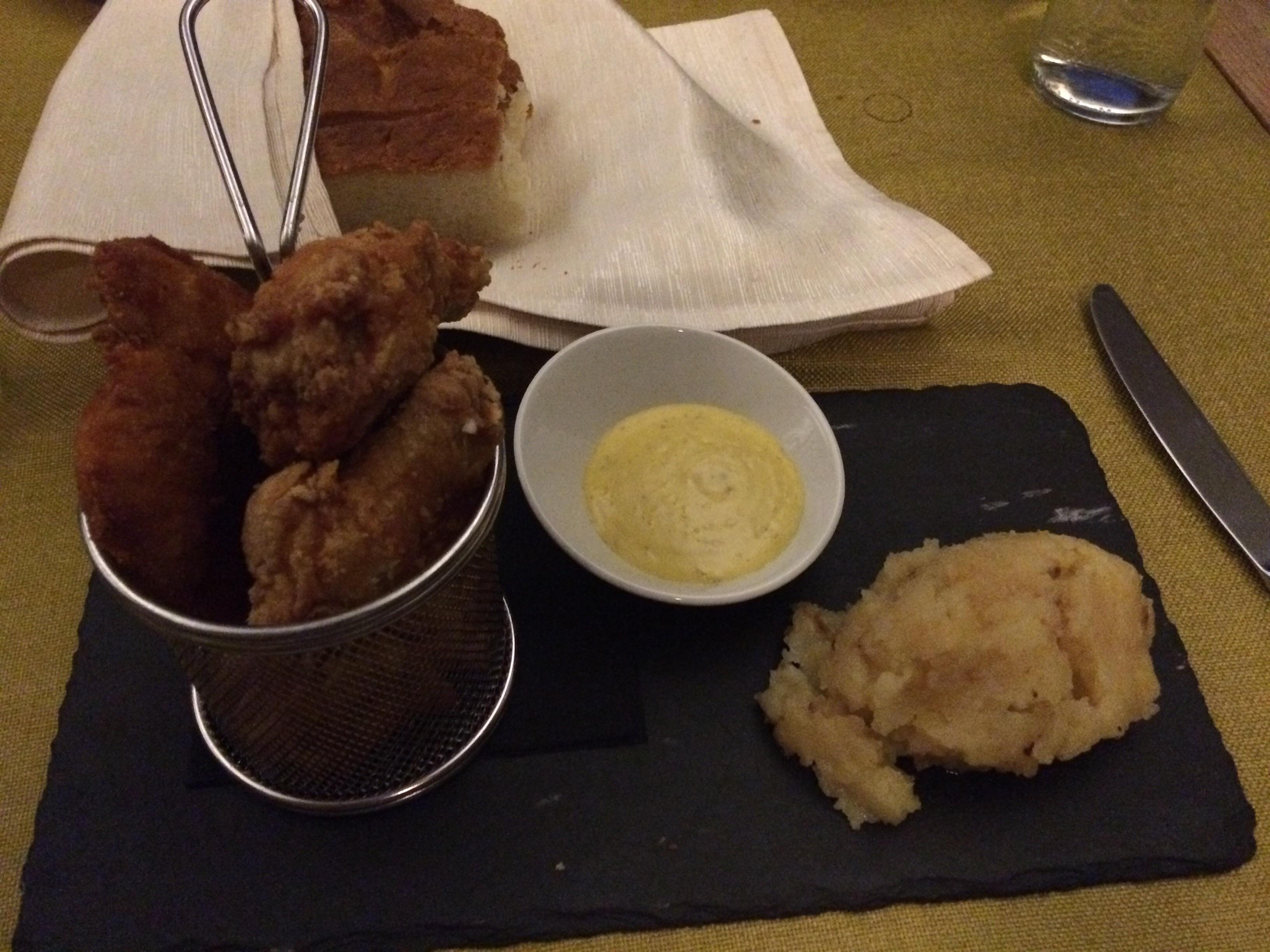 Chicken in a basket, "mayo" in a asymmetrical bowl and potatoes in a