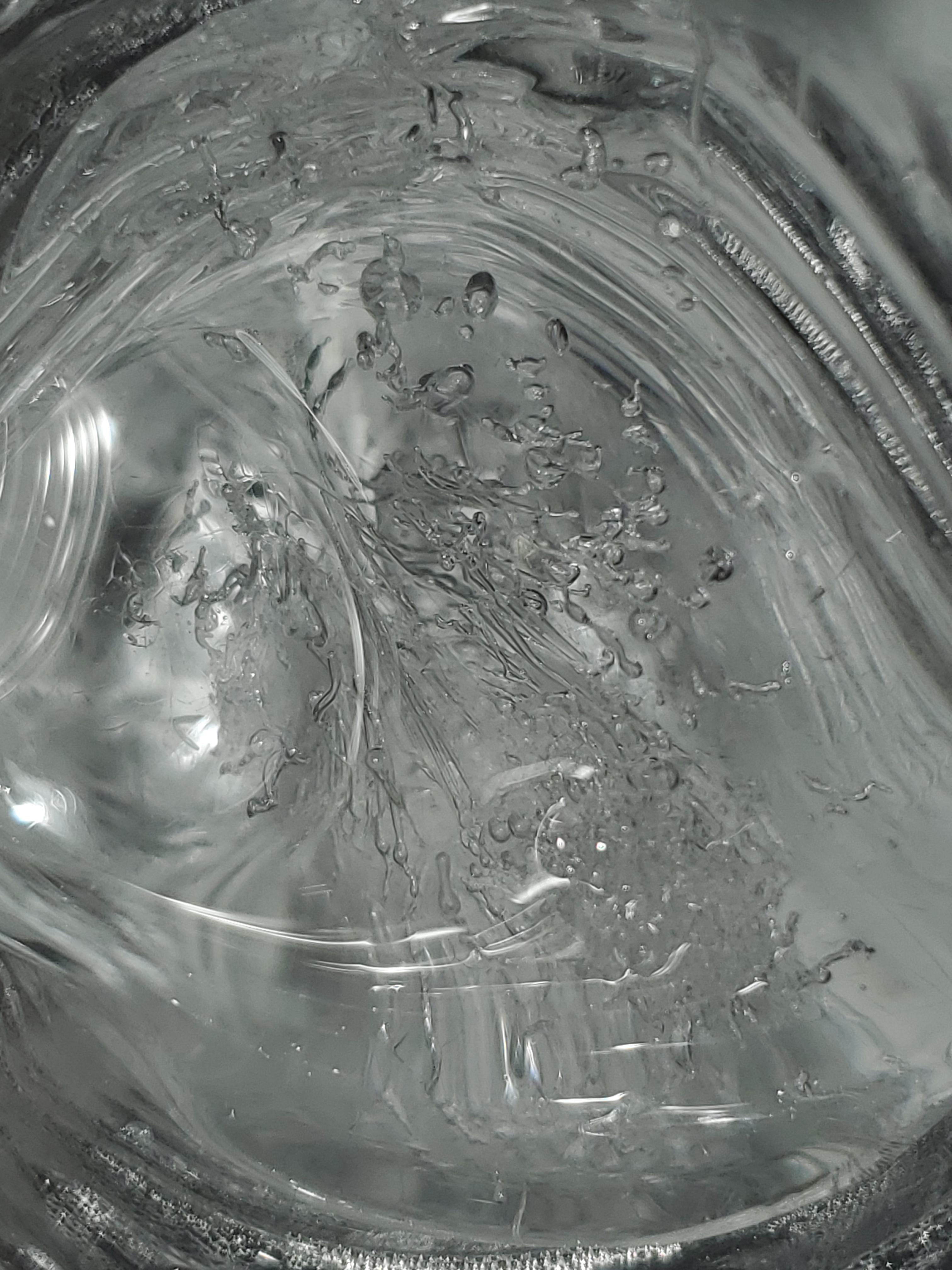 Frozen water particles in clear ice inside a water bottle r/pics