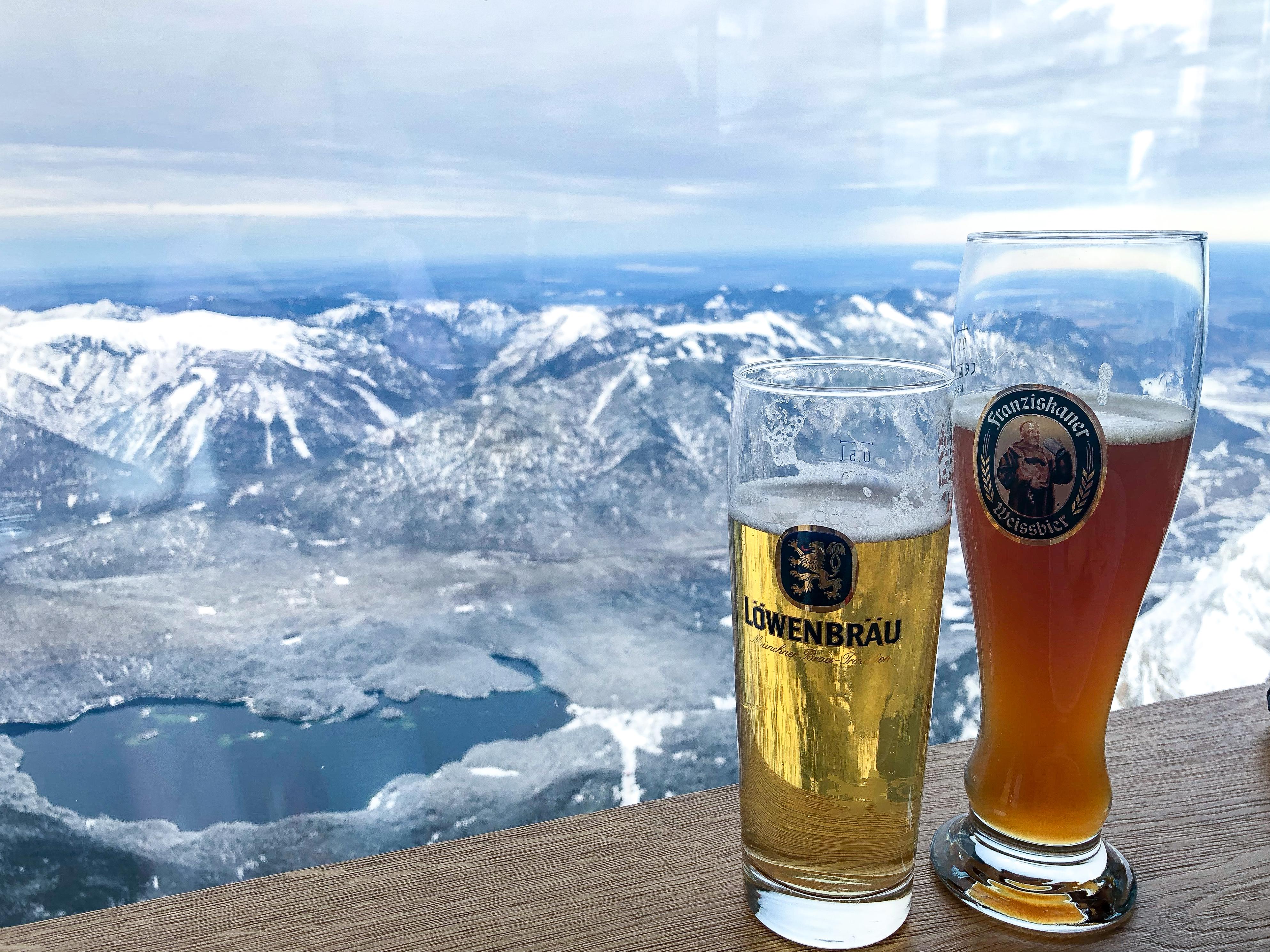 His and her beers with mountain views, on top of Zugspitze mountain