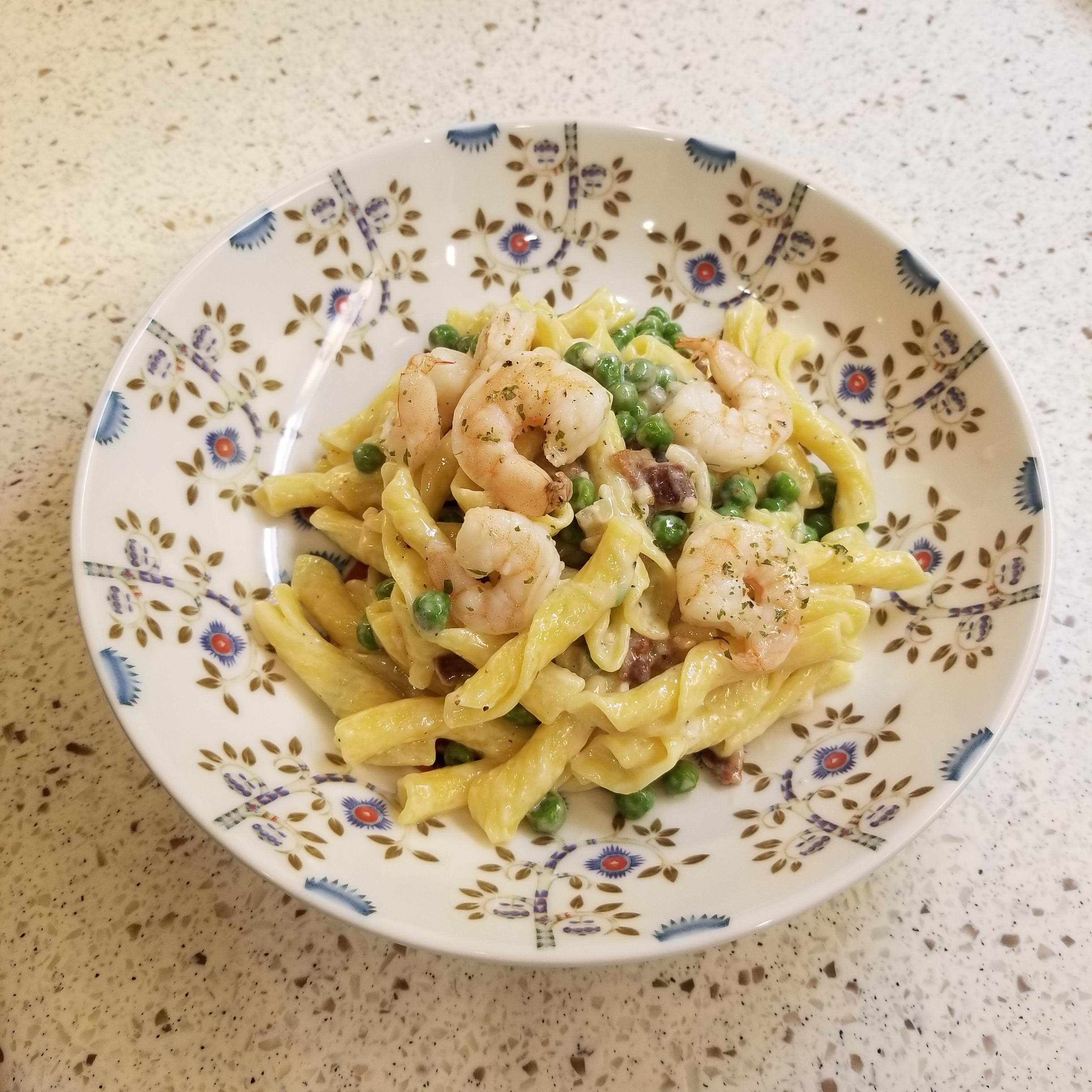 Pasta with a garlic bacon cream sauce, peas, and garlic shrimp. Corona
