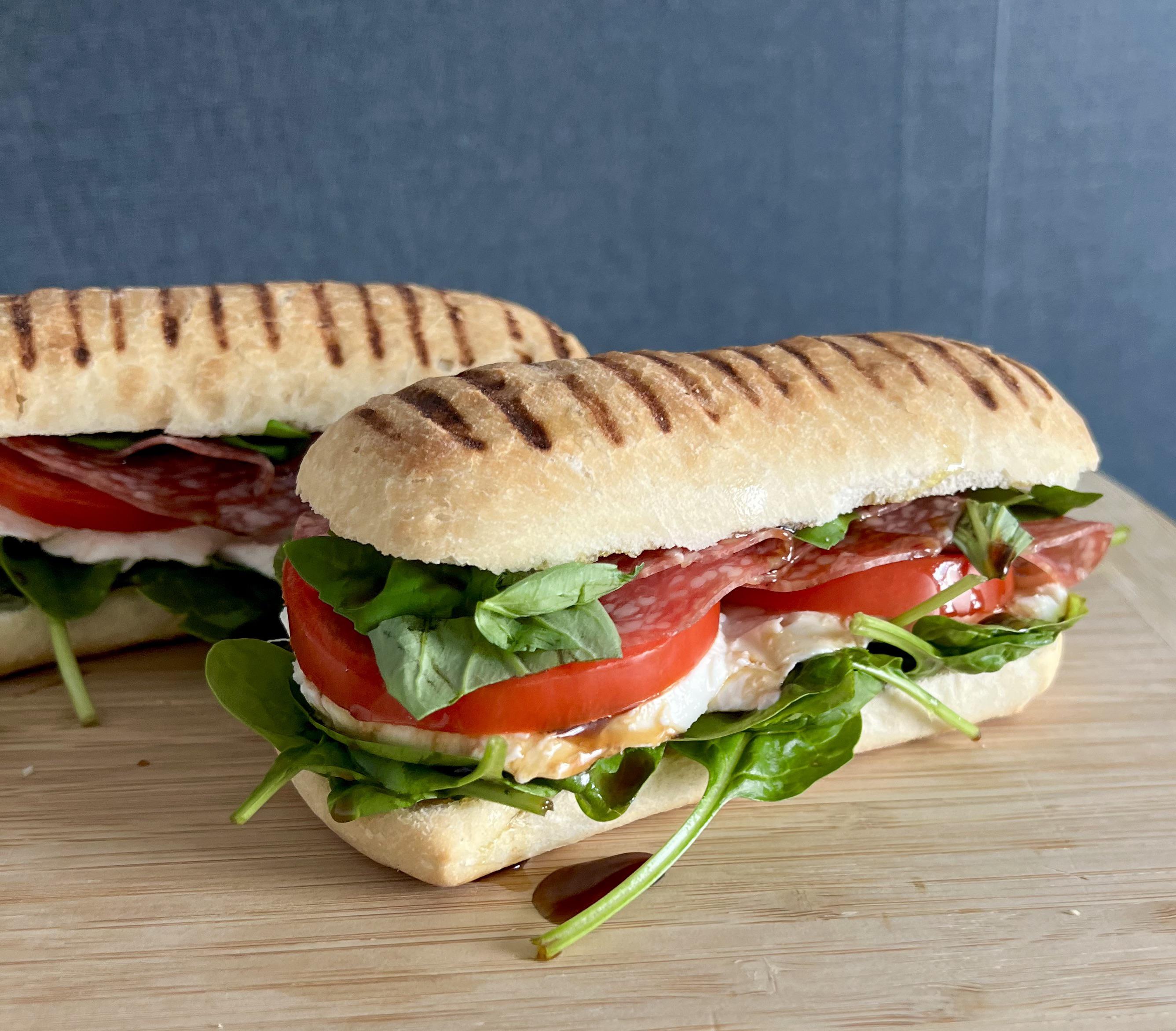 Caprese on ciabatta. Mozzarella, tomato, salami milano, with spinach, basil, olive oil and
