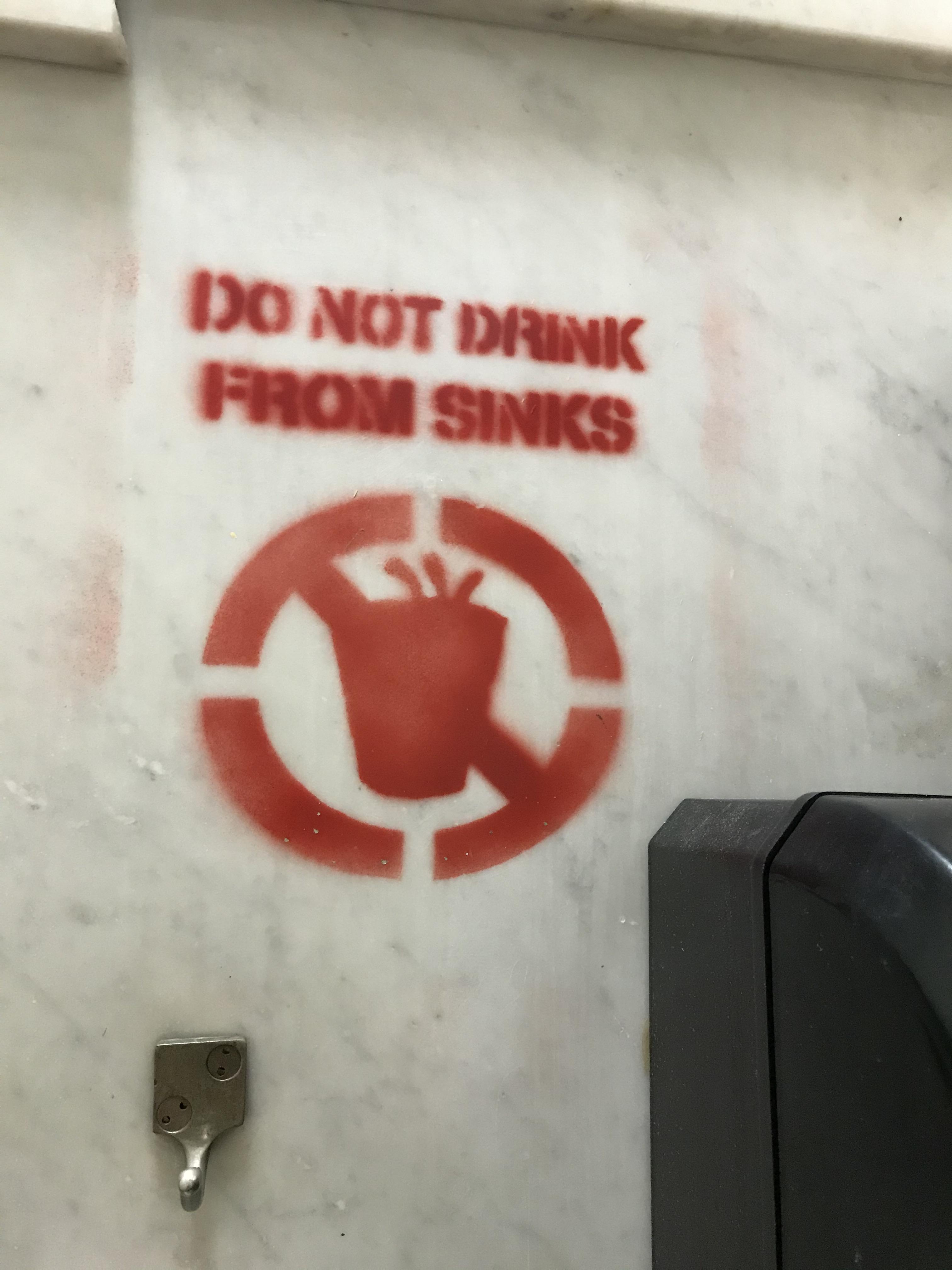 Spray painted on the wall of every bathroom in the school where I work r/ScarySigns