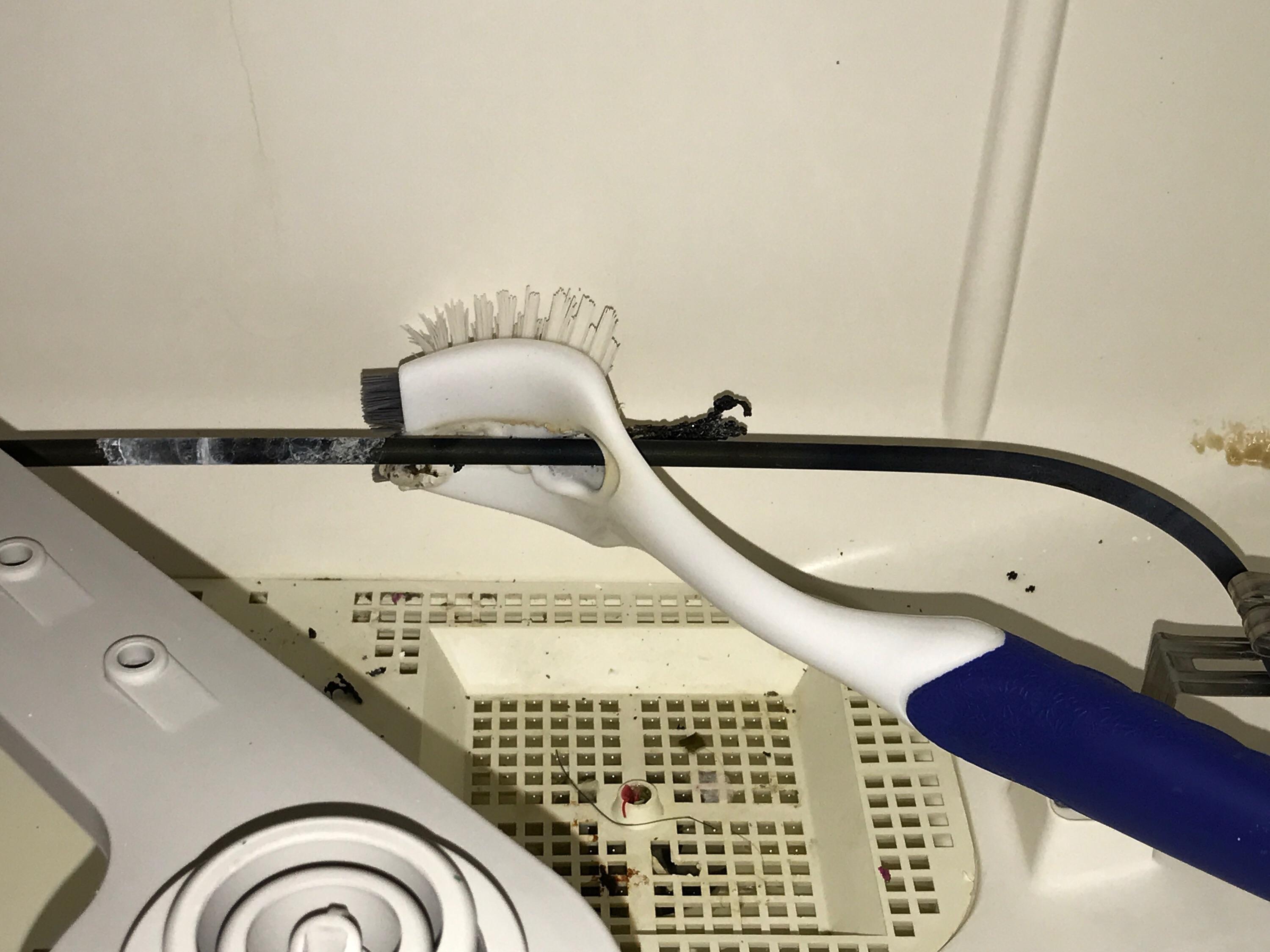 Brush fell onto the dishwasher's coil and melted straight through it and cooled so it was stuck