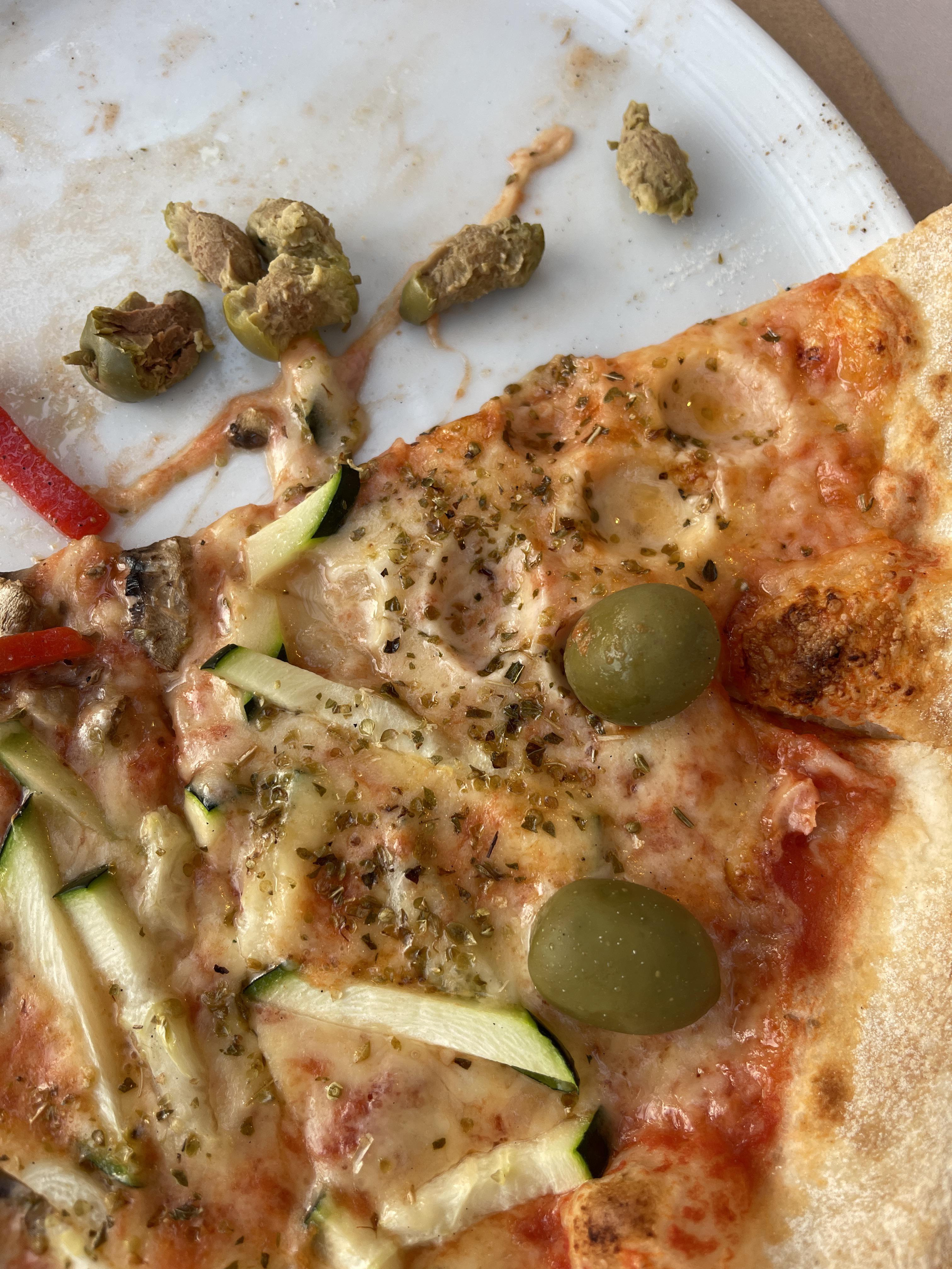 The olives on this pizza still have pits in them, so you can't eat them