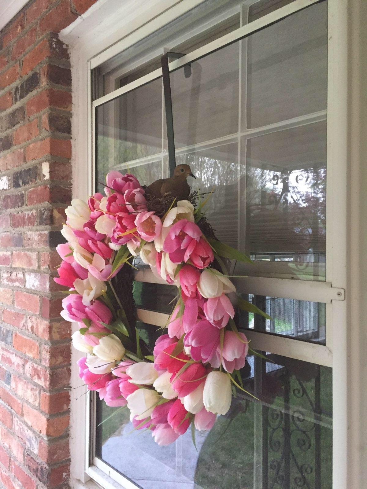 A bird made a nest and laid eggs in this fake flower wreath my Mom put