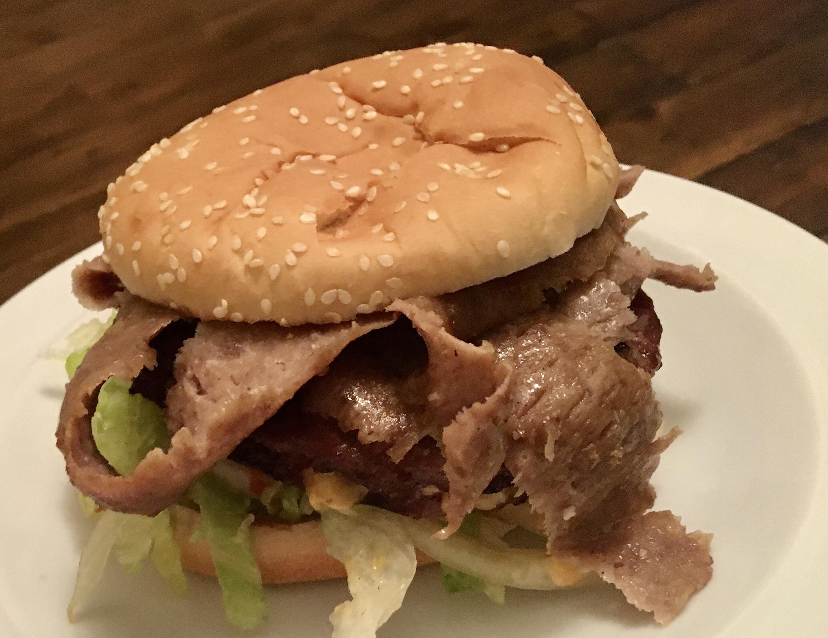 Half pound burger with cheese and lamb doner meat soaking up the