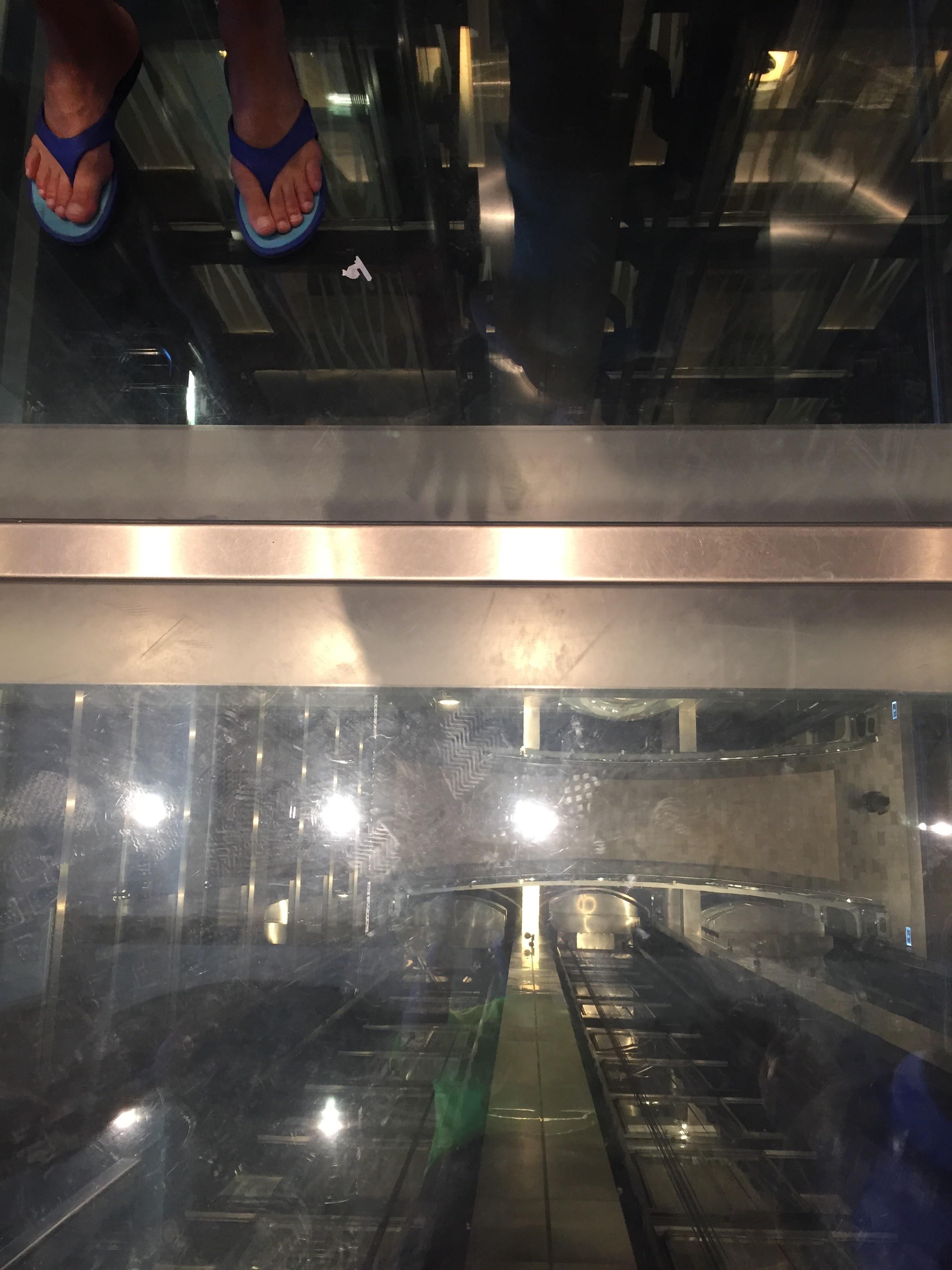 Looking down the elevator shaft through a glass bottom elevator r